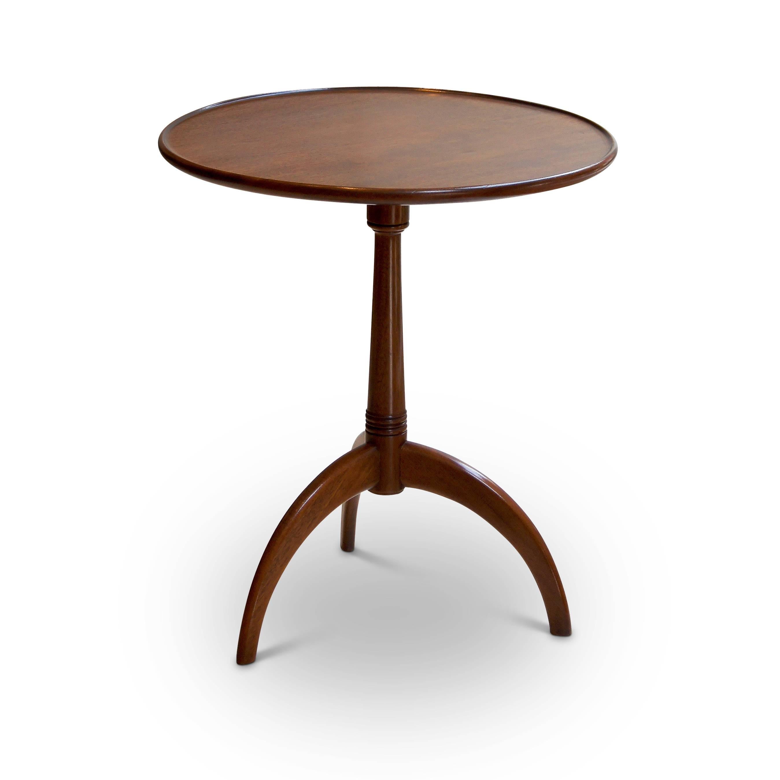 Round occasional / lamp table by Frits Henningsen (1889-1965), having turned pedestal support on trio of dynamically poised legs and carved contouring and lip around top edge. 

This wonderful table is a fine example of both Henningsen's