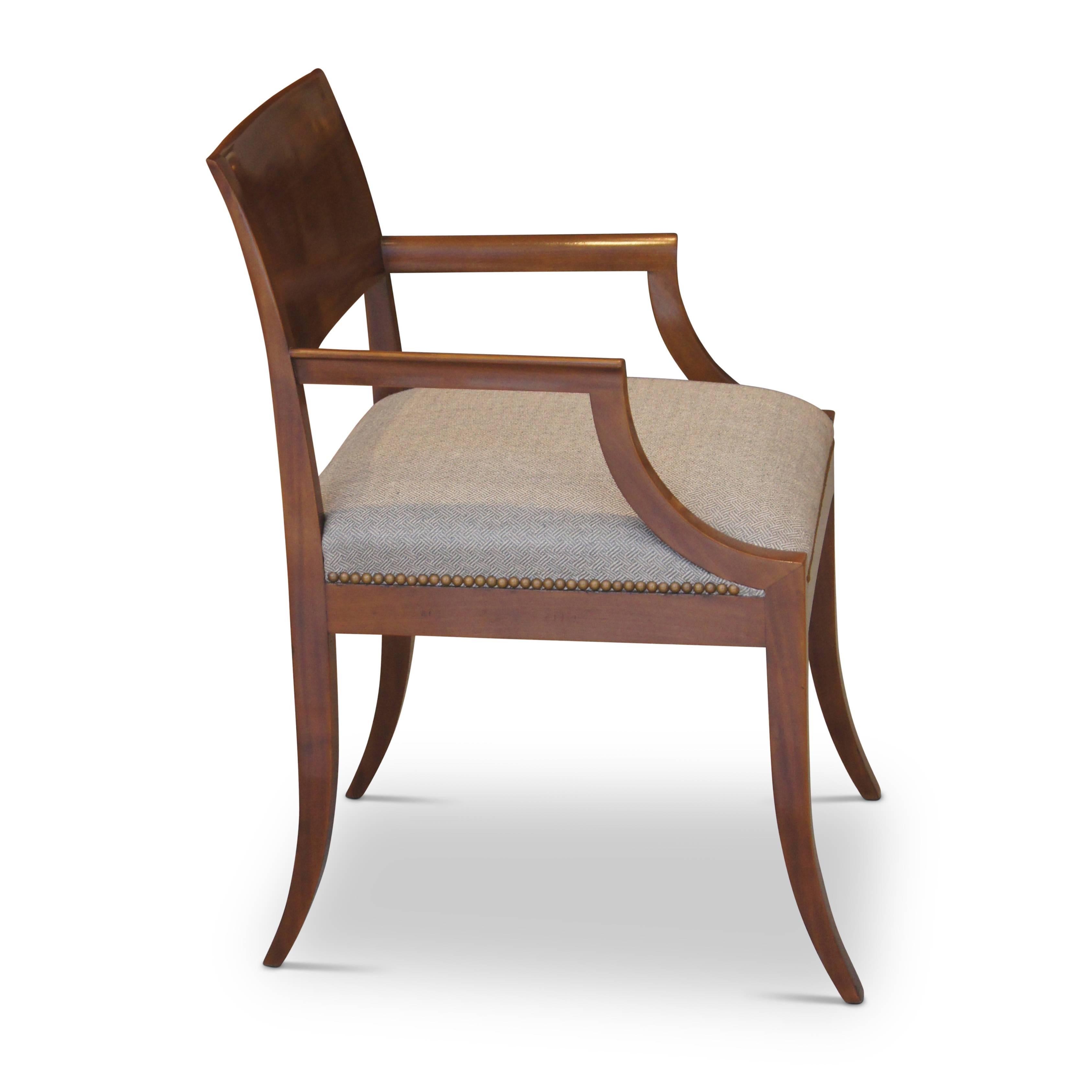 Pair of elegant Art Deco armchairs in mahogany by esteemed Danish cabinetmaker Rud Rasmussen, featuring crisp lines, klismos-style back rail, sabered legs and arms stepped back with cavetto supports. Crafted in 1927 (as verified by the RR archives
