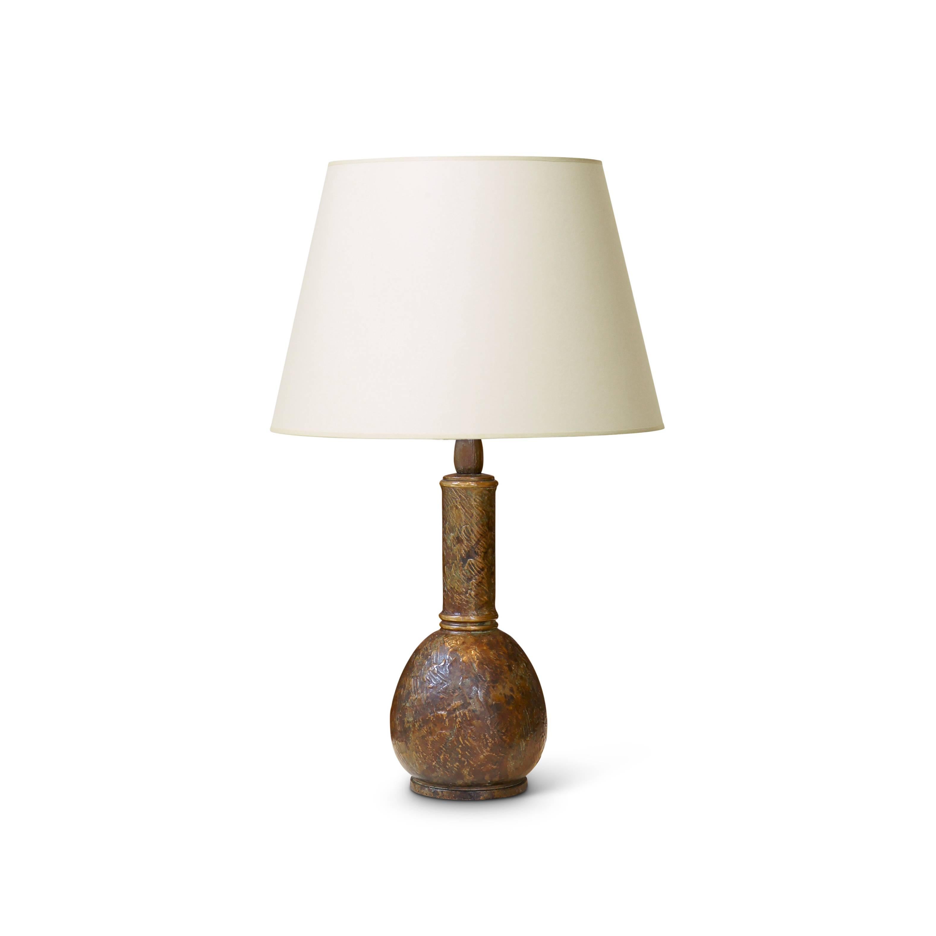 Table lamp by master metal founder and artist Evan Jensen (1888-1978), having a bulb/drop shape base on a reveal plinth and having a long neck (model 654), articulated with burnished ring motifs at base and top of neck and having entire surface