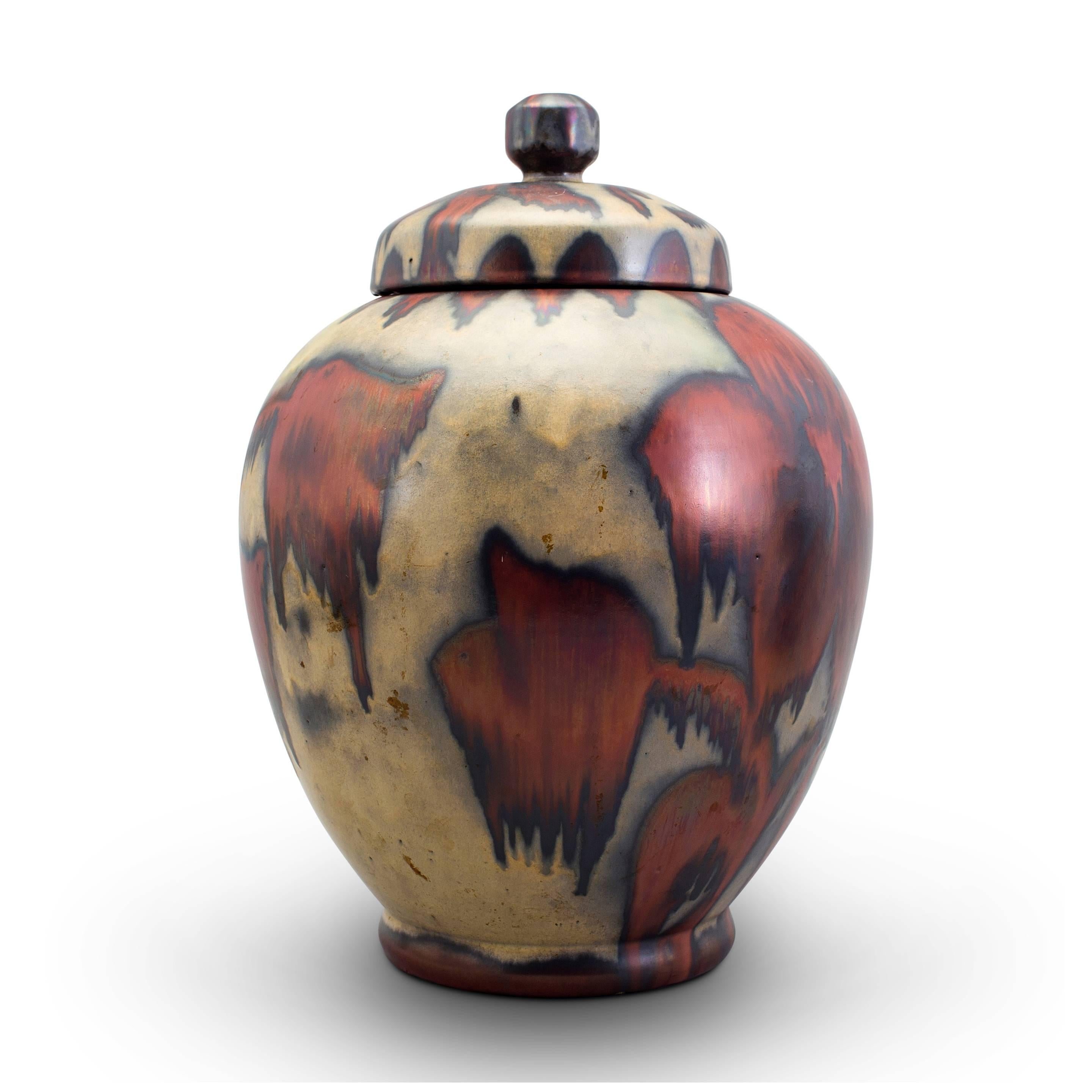 Extraordinary fine lidded vase by Höganäs possibly Edgar Bockman (1890-1981), having a tapering ovoid form with bead foot and cap lid with finial; with wonderfully moody and evocative abstracted floral pattern in a copper hue lustre over nacreous