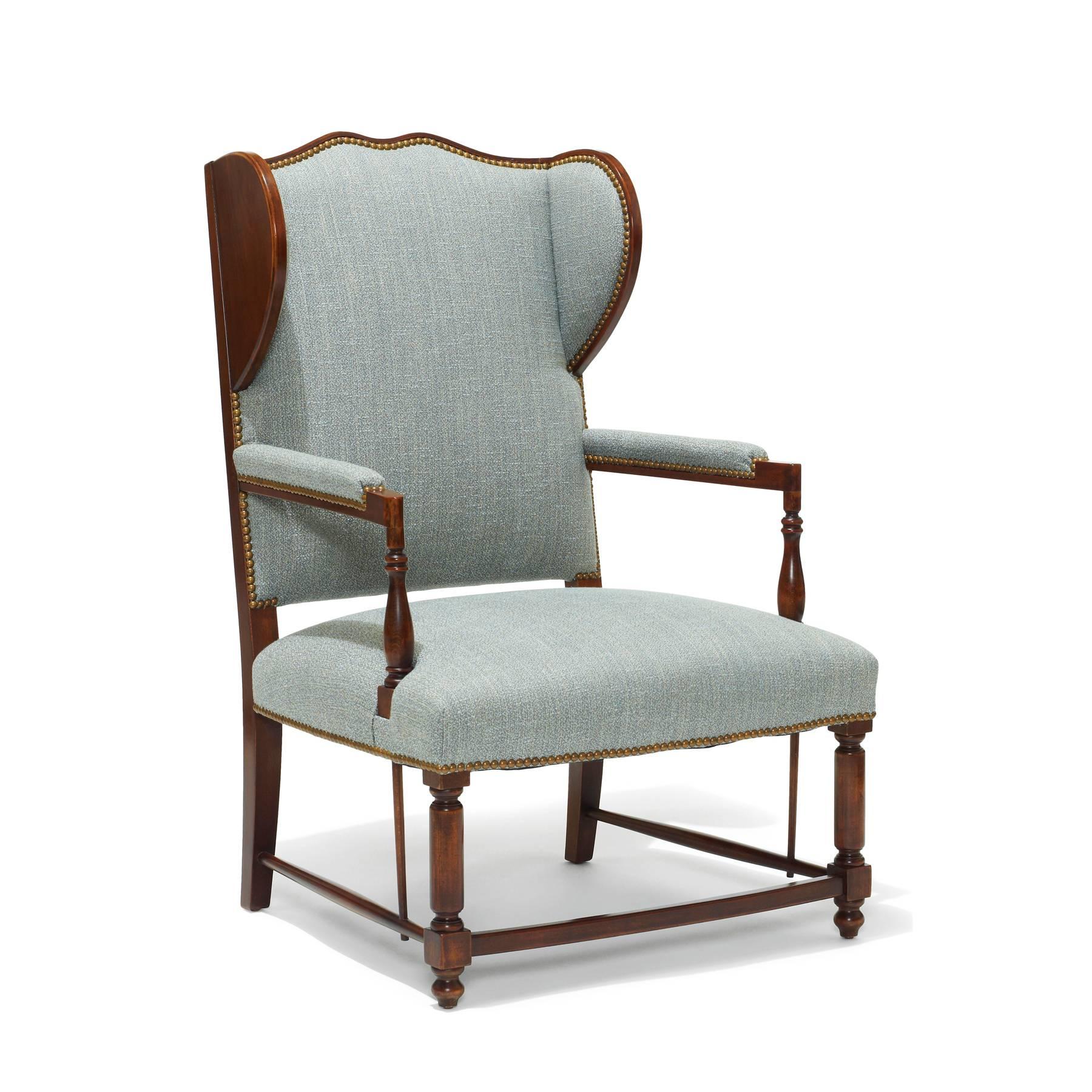 A most handsome pair of Swedish Art Deco reinterpretations of traditional winged back armchairs, having exposed stained birch frames with turned detailing and wooden backed wings adding a sense of structure, warmth, and vernacular charm. The birch