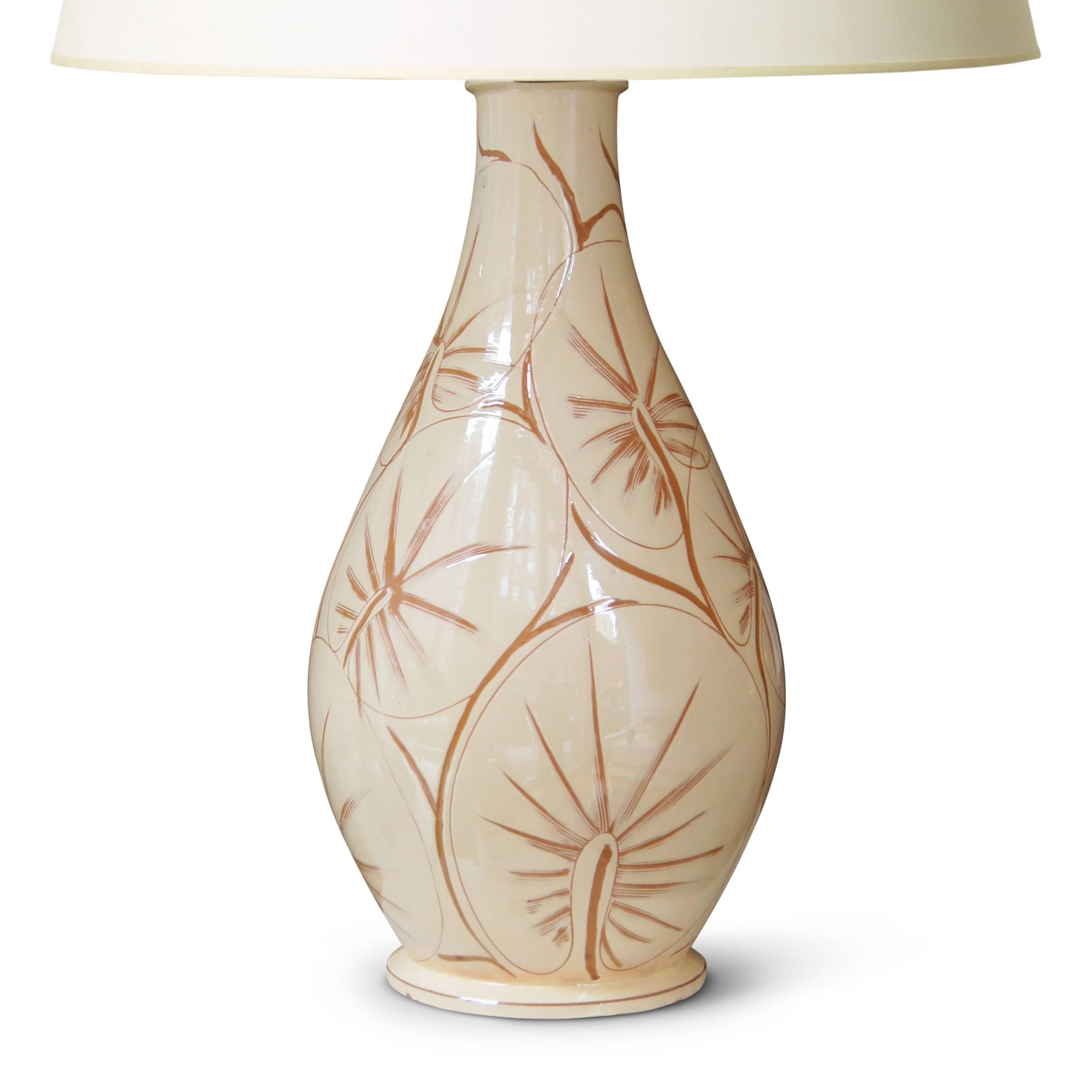 Monumental / tall table lamp with vase form by Kähler Keramik, in hand-turned earthenware, glazed in ivory and incised with a vigorous and masterful sgraffito pattern of tropical leaves of an orbicular or palmate sort; Denmark, mid-20th century,