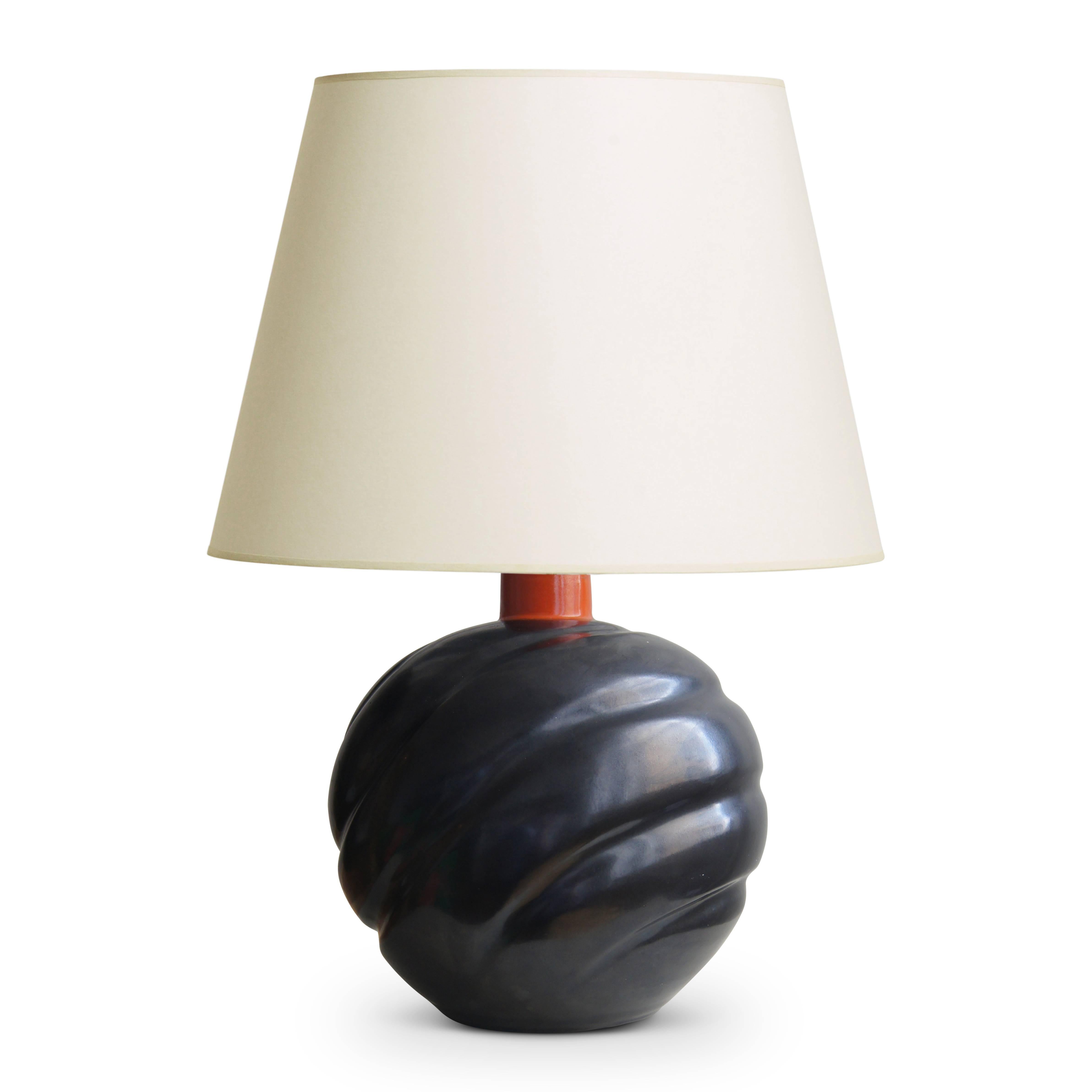 Striking and uncommon table lamp from Upsala-Ekeby, having a spherical form sculpted with an undulating pattern of concentric circles rippling across the surface at a diagonal, highlighted with a magnificent dark bronze/charcoal luster glaze with a
