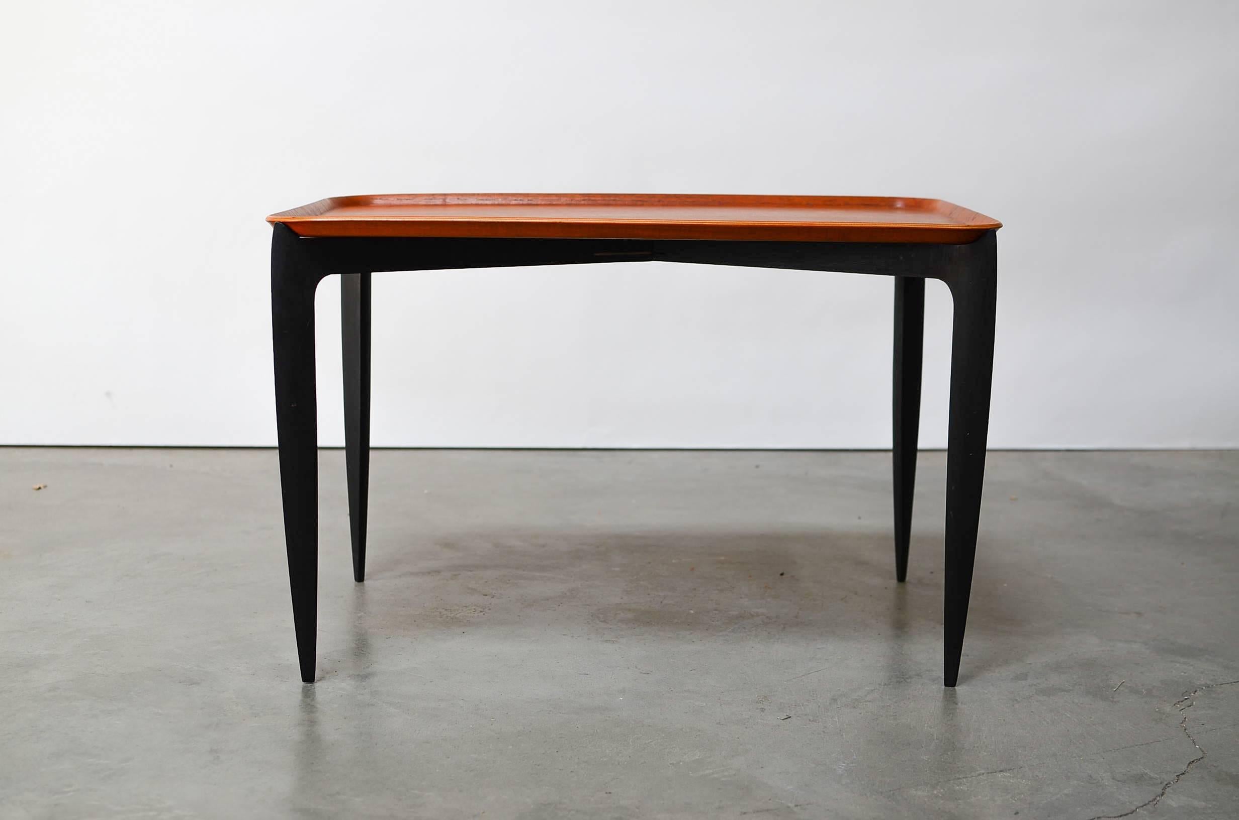 Rare rectangle version tray table designed by Svend Aage Willumsen & H. Engholm and made by Frtiz Hansen. Table folds flat for easy storage when not in use. When open, the sleek tapered black legs support the teak top with a raised lip. Both pieces