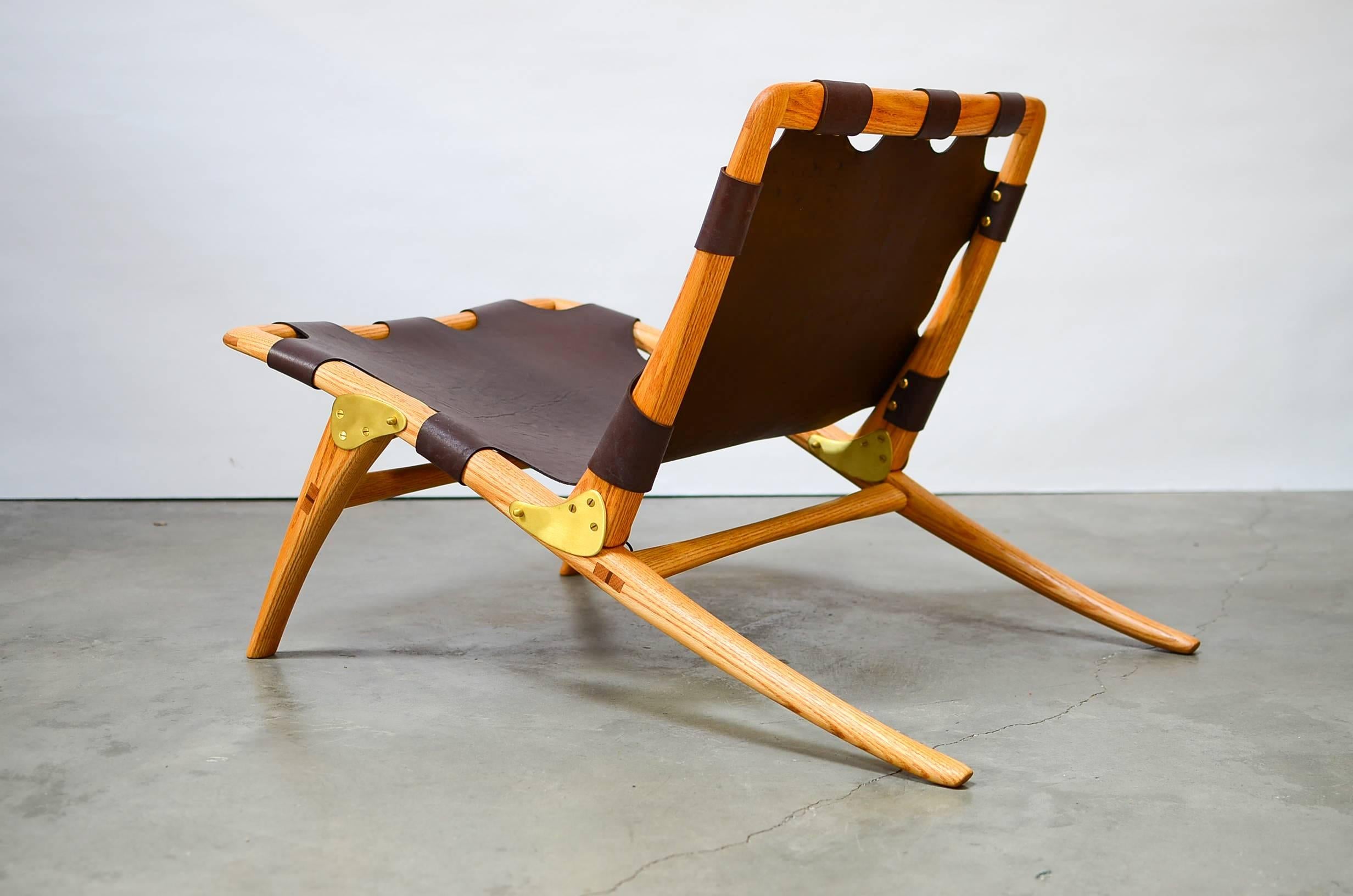 Exquisite folding lounge chair executed in Eastern red oak with a single hide leather sling with brass fittings designed by master craftsman Dean Santner. Letter of provenance included by designer. 

This is the only example ever made.