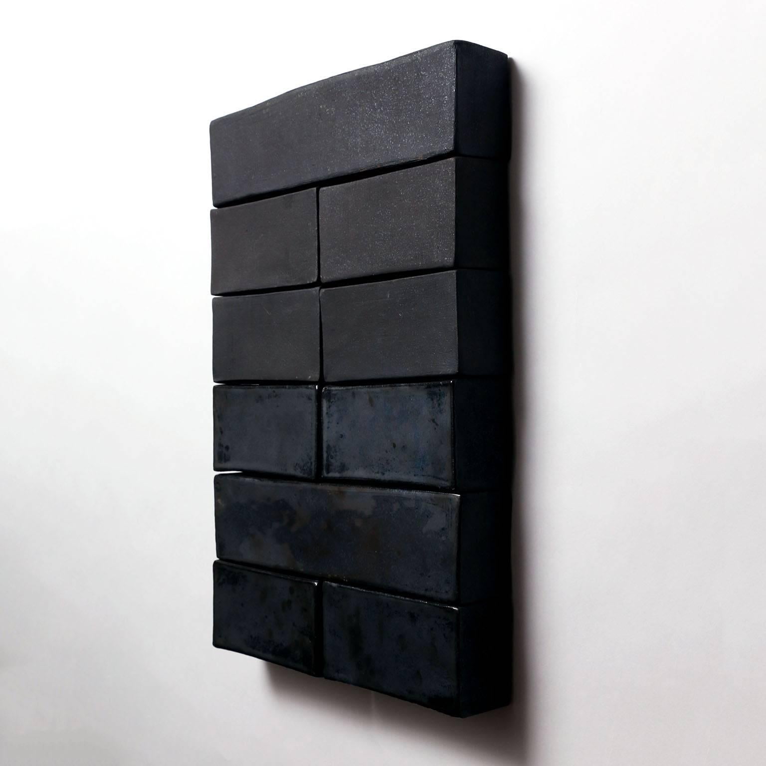 Amazing ceramic wall sculpture by ceramic artist, John Sheppard, circa 2016. This piece features two different style glazes, a beautiful iridescent black glaze and a black matte coal glaze which make for a very pleasing contrast. 

Artist