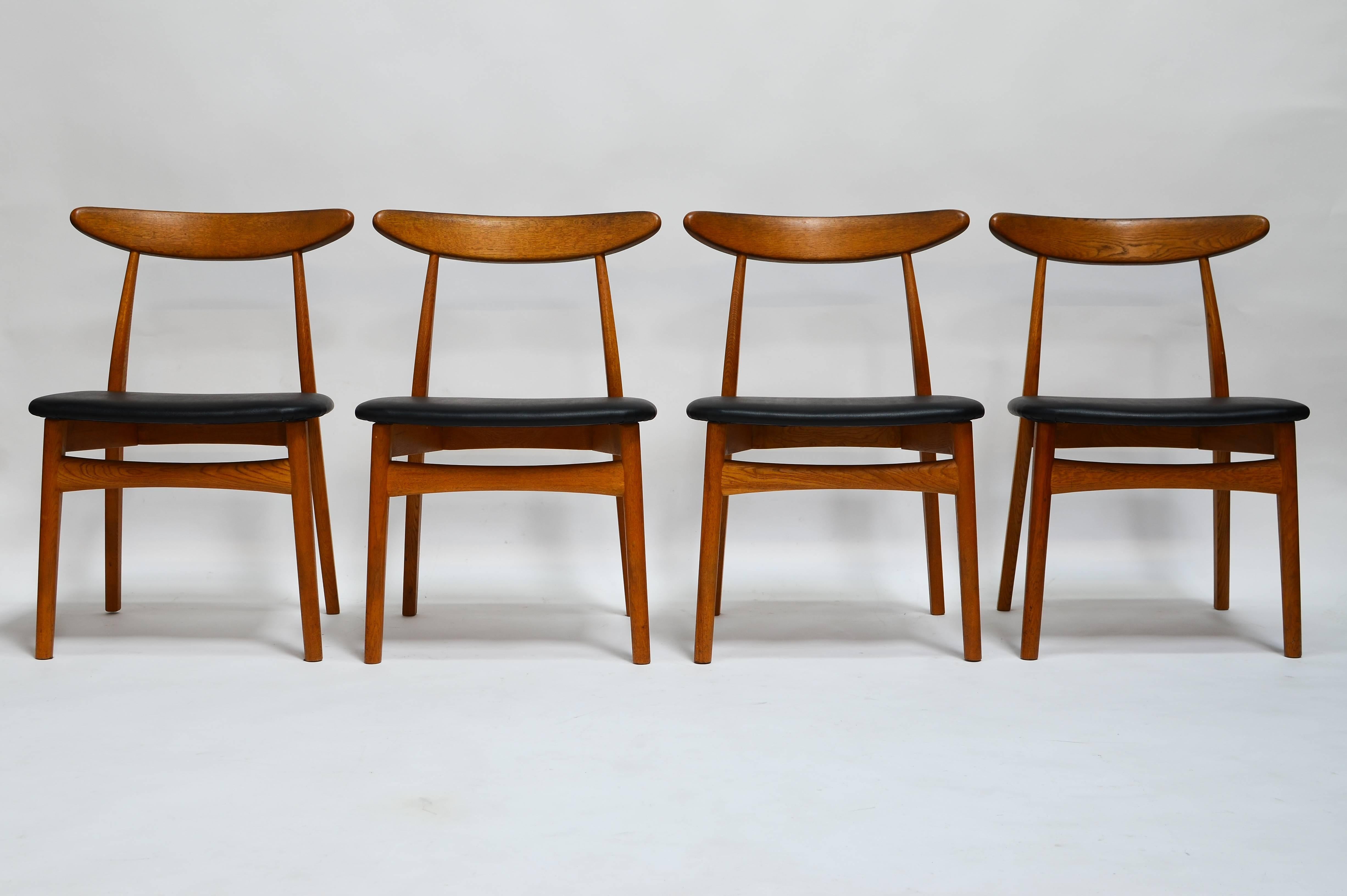 A wonderful set of 8 Mid Century Modern Dining Chairs. The chairs look very Scandinavian, similar to a Hans J. Wegner design, yet are Japanese in origin dating to the late 1950's.

These have been recently upholstered in black Naugahyde and expert
