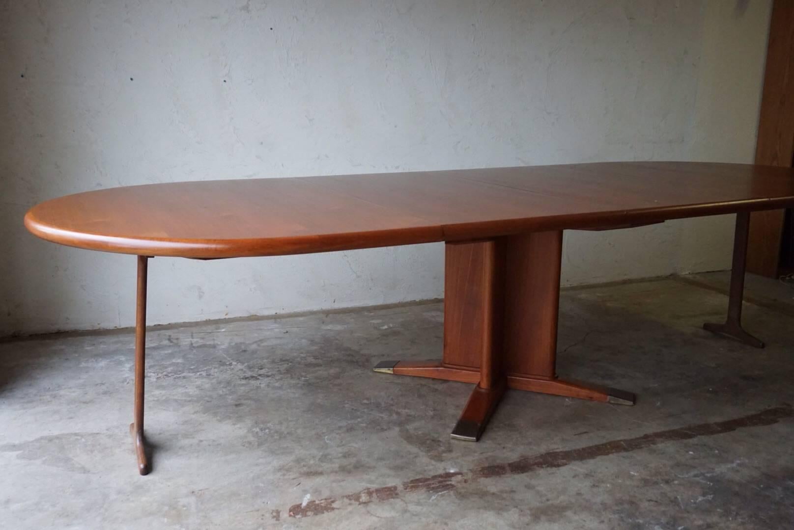 Exceptional dining table, solid teak, on a four-star pedestal base with brass leg caps designed by Frits Henningsen. This is a stunning piece. Included is two leaves making the table 113" long.