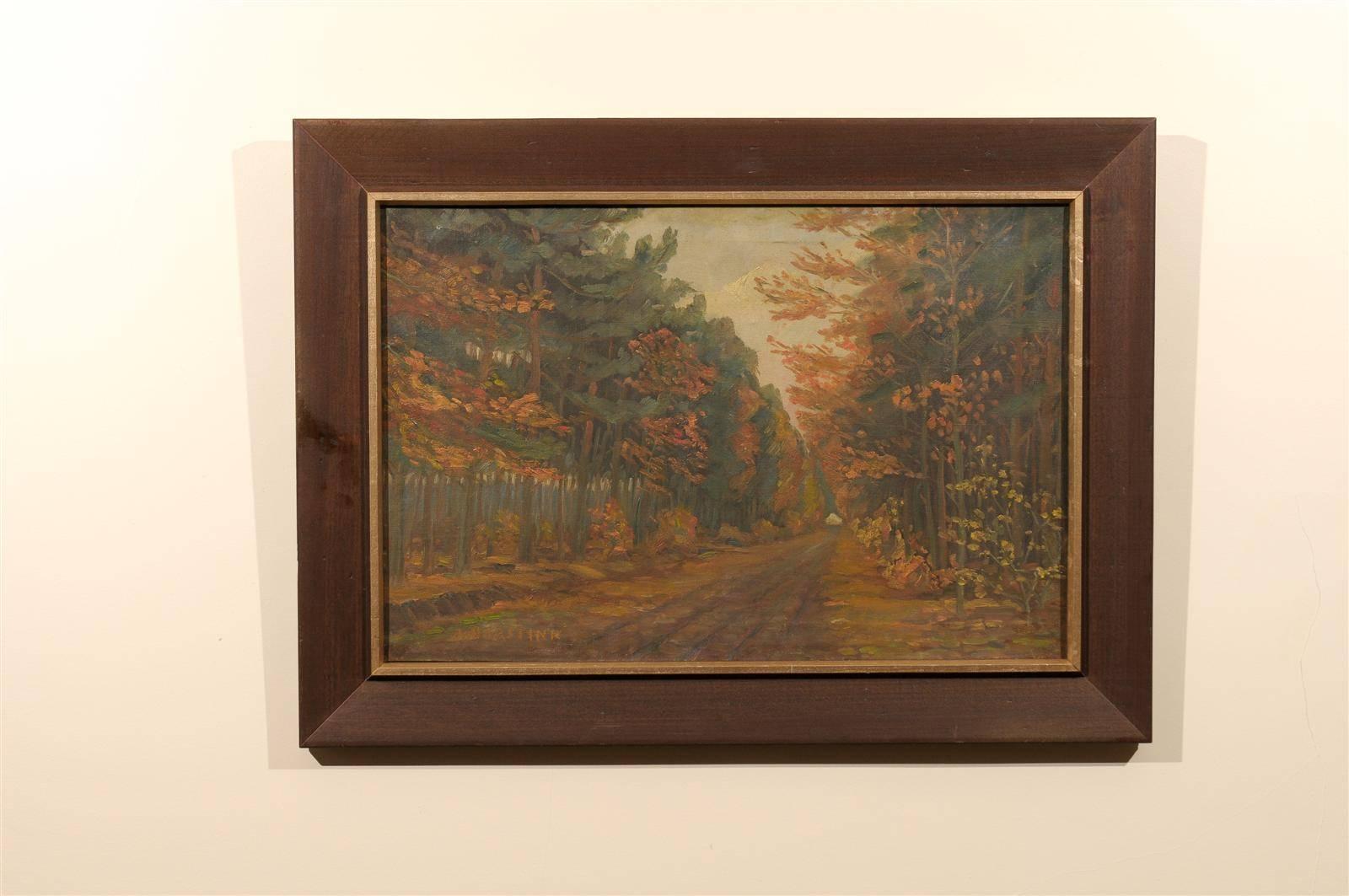 Early 20th century Art Deco Dutch oil on canvas in the Impressionist style of a dirt road flanked by trees in autumn showing the changing of the seasons. The painting is rich in hues of gold, orange, and green. The painting is signed Horstink bottom