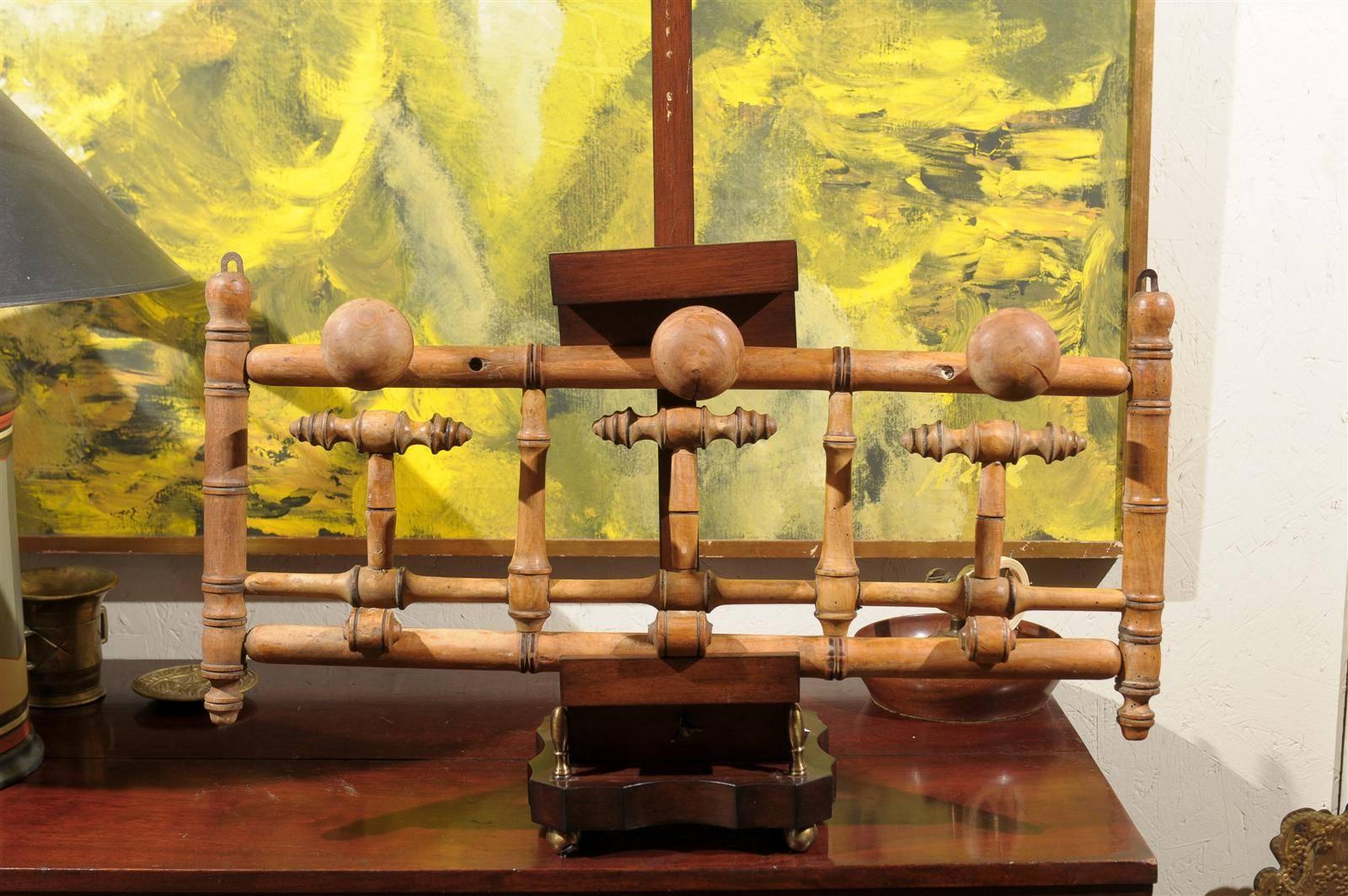 19th century French wall mounting coat or hat rack of turned pine with three fixed upper knobs and three lower knobs that can be pulled down for additional storage.