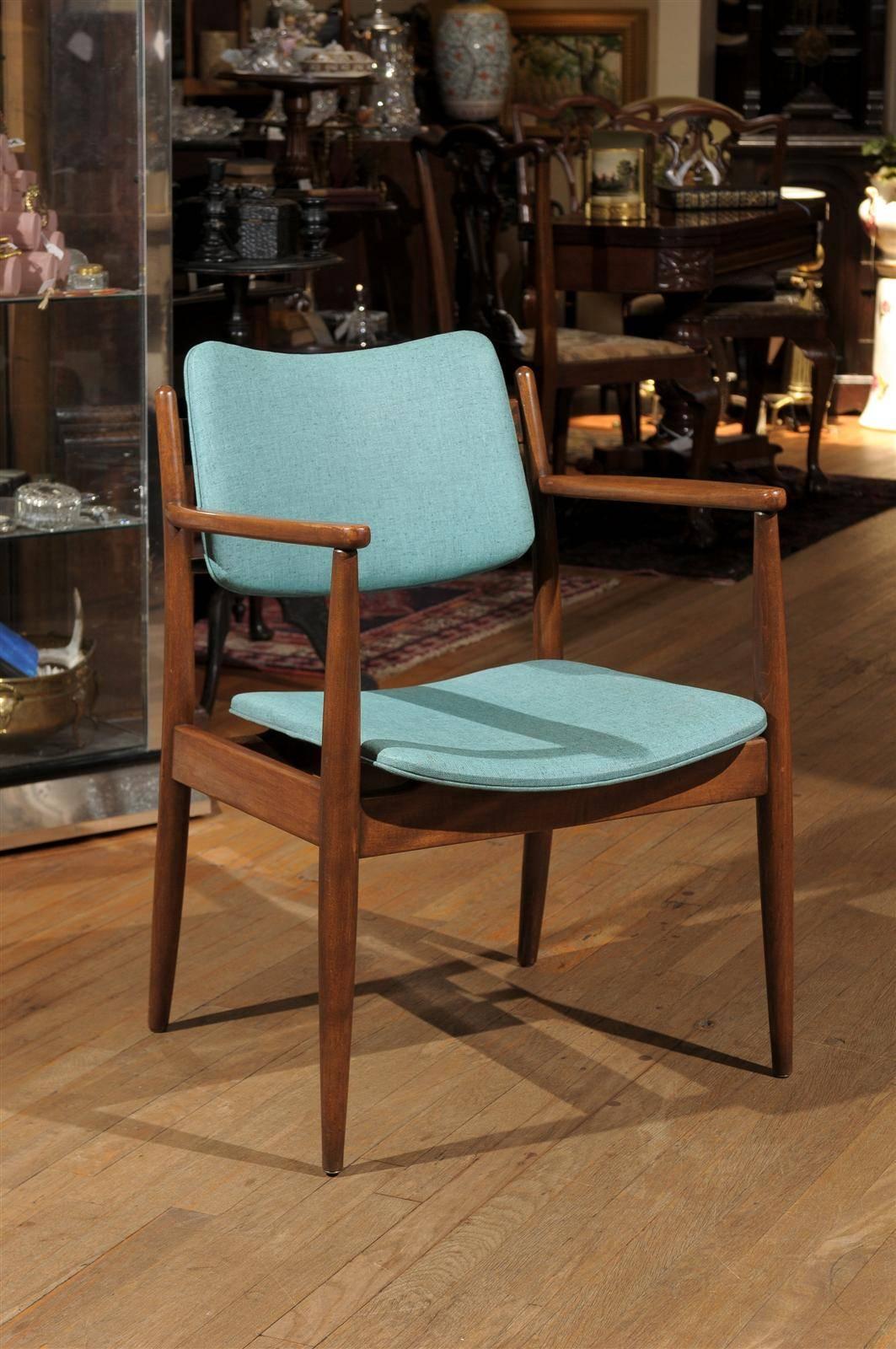 Sculptural solid walnut and upholstered occasional chair after Finn Juhl. The chair has tapered legs, a subtly curved chair back and retains its original turquoise vinyl upholstery.