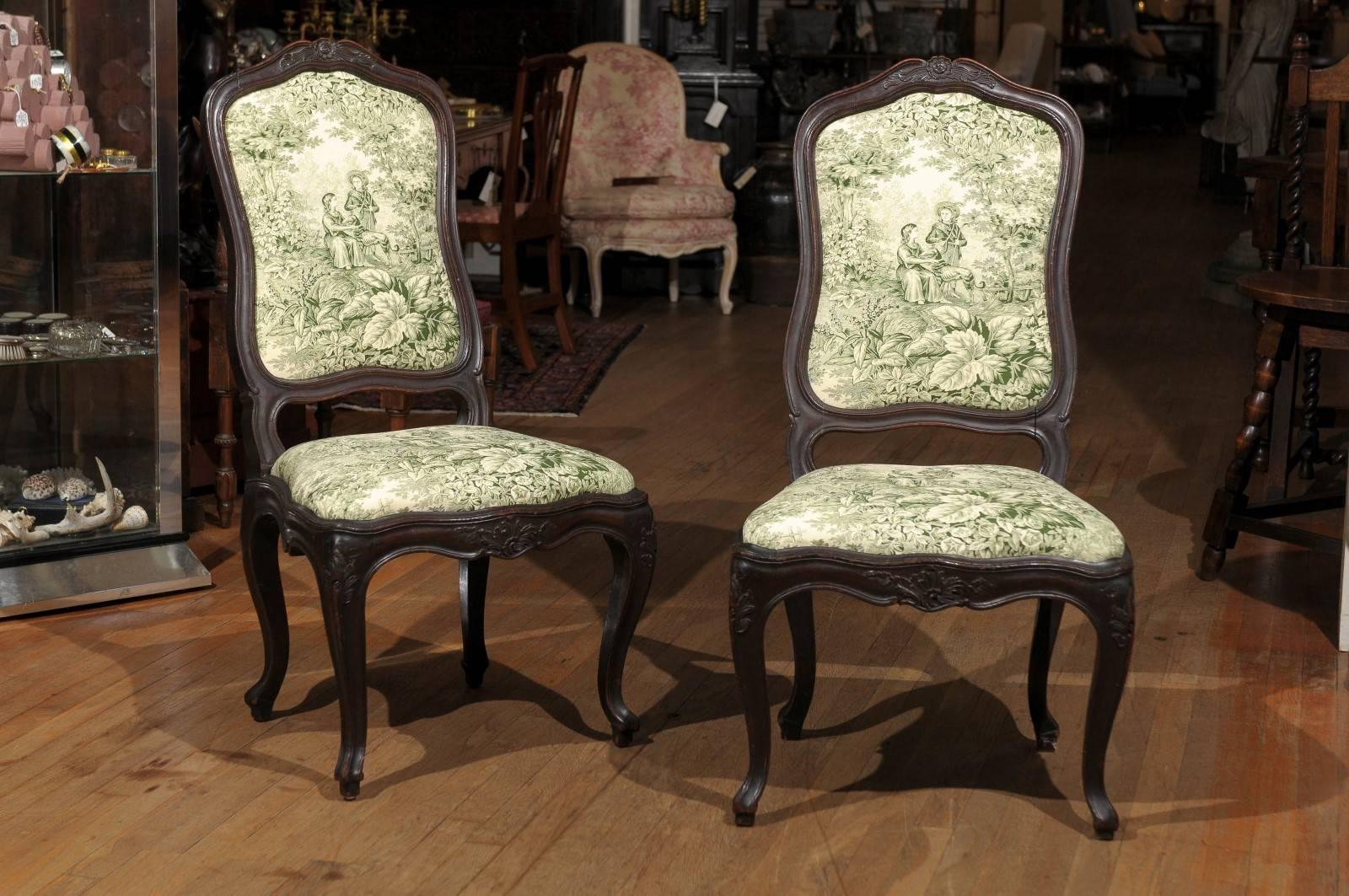 Early 20th century French provencal pair of side chairs carved of oak in the Louis XV style and newly upholstered in an ivory and green toile.