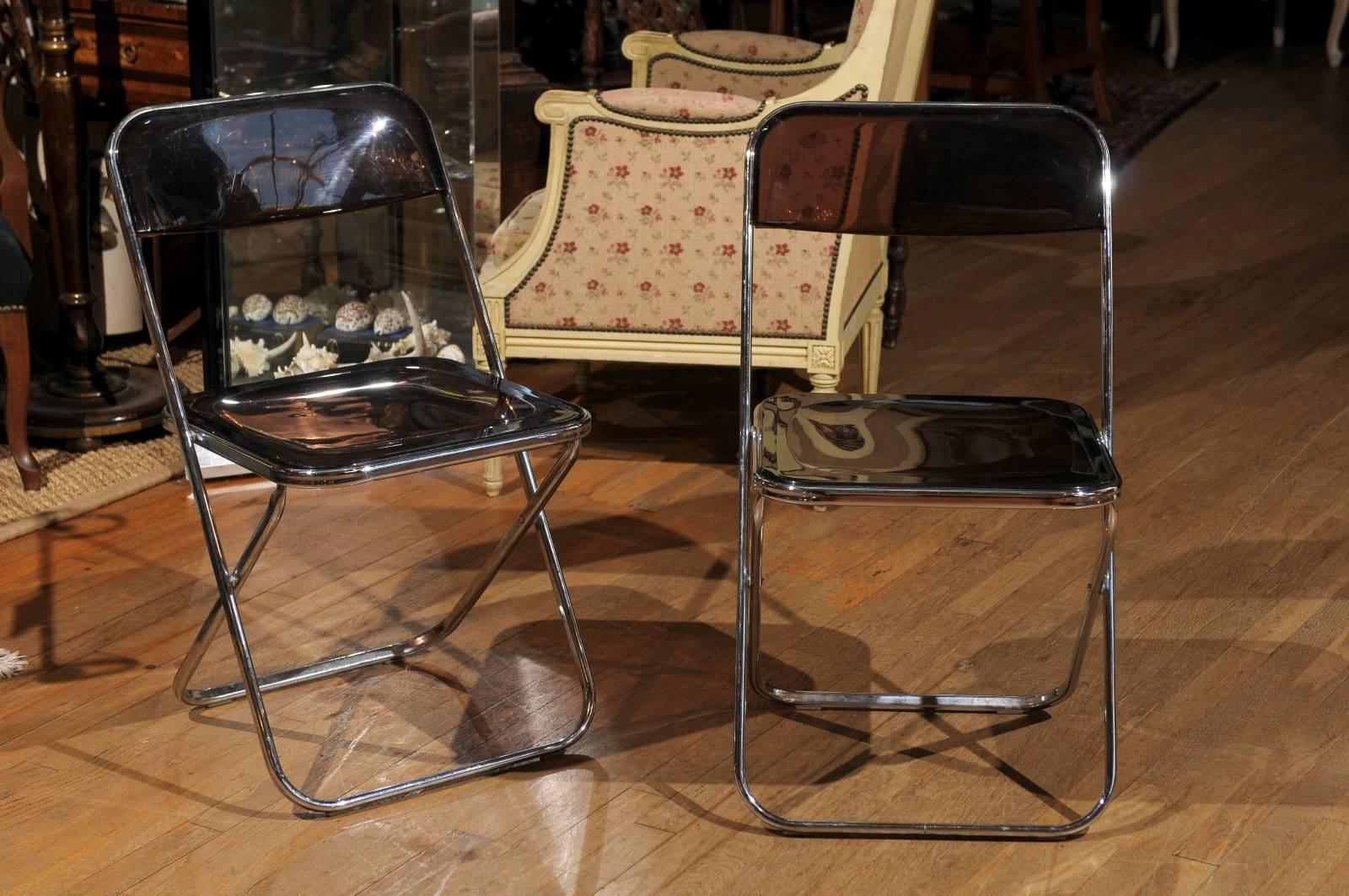 Vintage set of four chrome and smoked Lucite folding chairs.