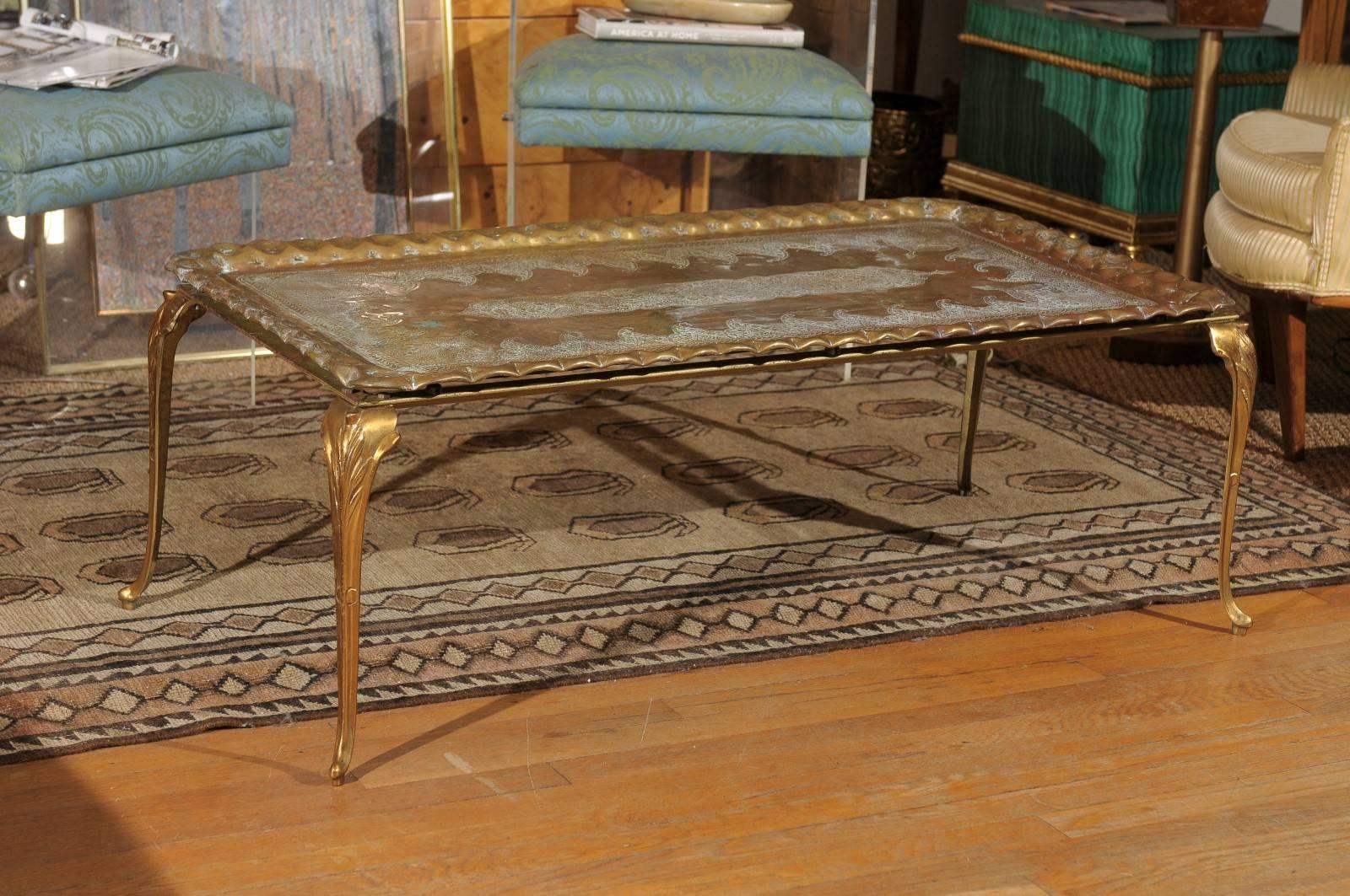 Mid-20th century etched and hammered rectangular oversized brass tray resting on a solid brass stand with cabriole legs.