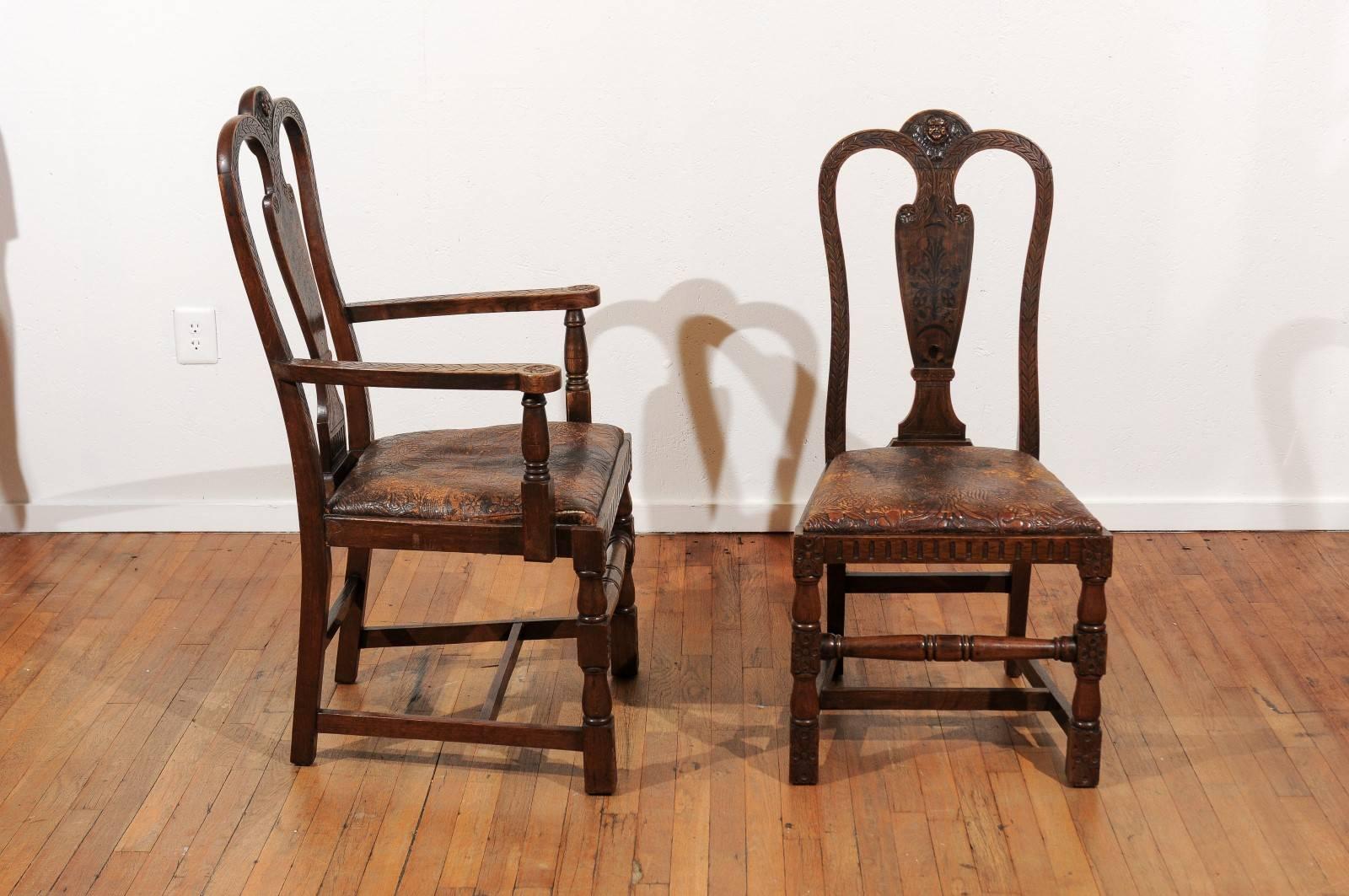 19th Century set of eight English dining chairs having two armchairs and six side chairs.  The chairs are made of solid oak with acanthus carved side and top rails surrounding a marquetry inlaid backsplat and crowned by a carved cherub.  The chairs