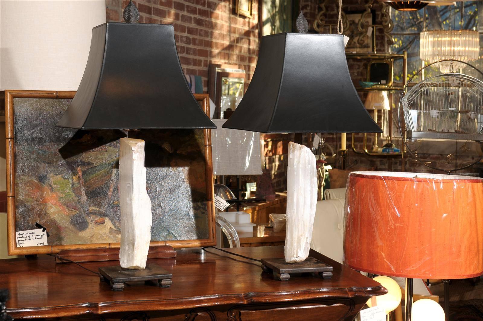 Pair of 20th century lamps, each having a large piece of selenite crystal custom mounted onto an iron rod and resting on an iron platform base. Black paper lampshades (24
