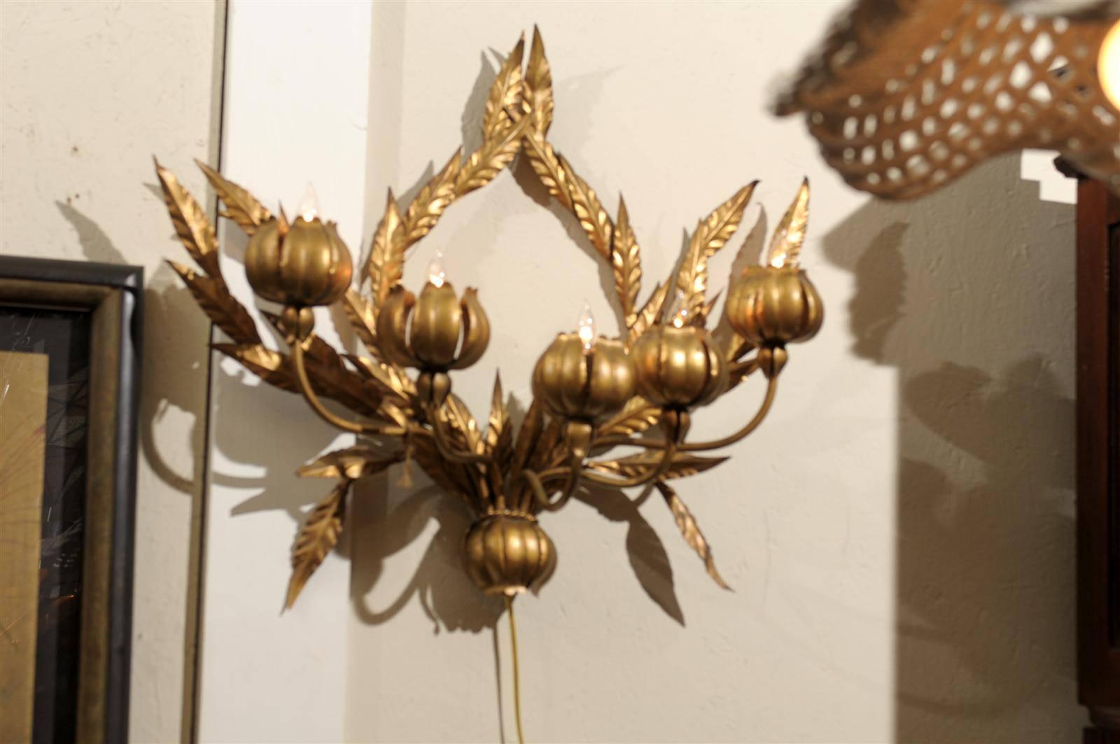 Mid century Italian five light wall sconce of gilded metal in the form of flowers and leaves, and in the Hollywood Regency style.  The fixture has been rewired for modern use.  