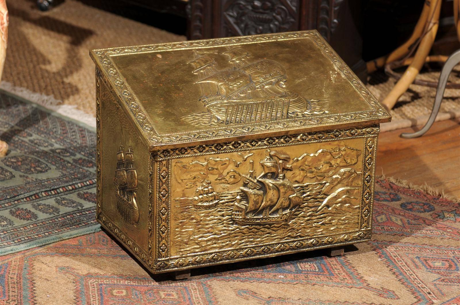 20th century English fireside coal hod or scuttle having a wood interior and covered with brass embossed with nautical ship motifs. Stamped Peerage England.