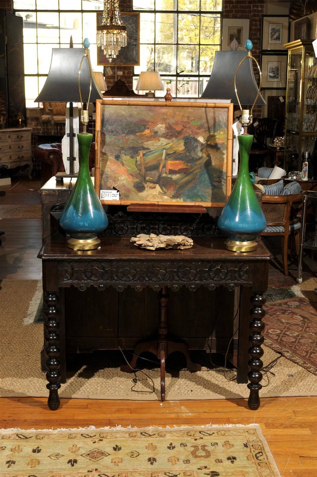 19th century narrow oak console with a beveled tabletop and carved wooden gallery over a carved frieze holding one drawer. The table rests on back block legs and turned bobbin legs on the front. The tabletop is 30.25