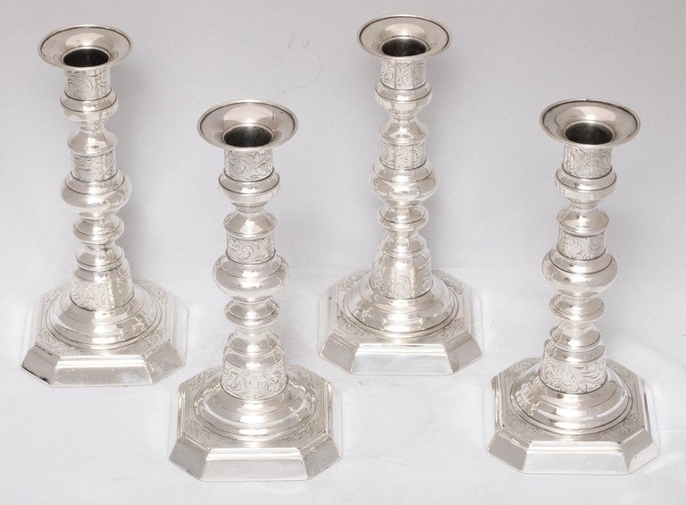 Suite of four, American, Colonial style, sterling silver candlesticks, The Gorham Corp., Providence Rhode Island, circa 1910. Each candlestick is etched. Bases are octagonal is shape. Each candlestick measures 7 1/8 inches high x 3 1/2 inches wide x