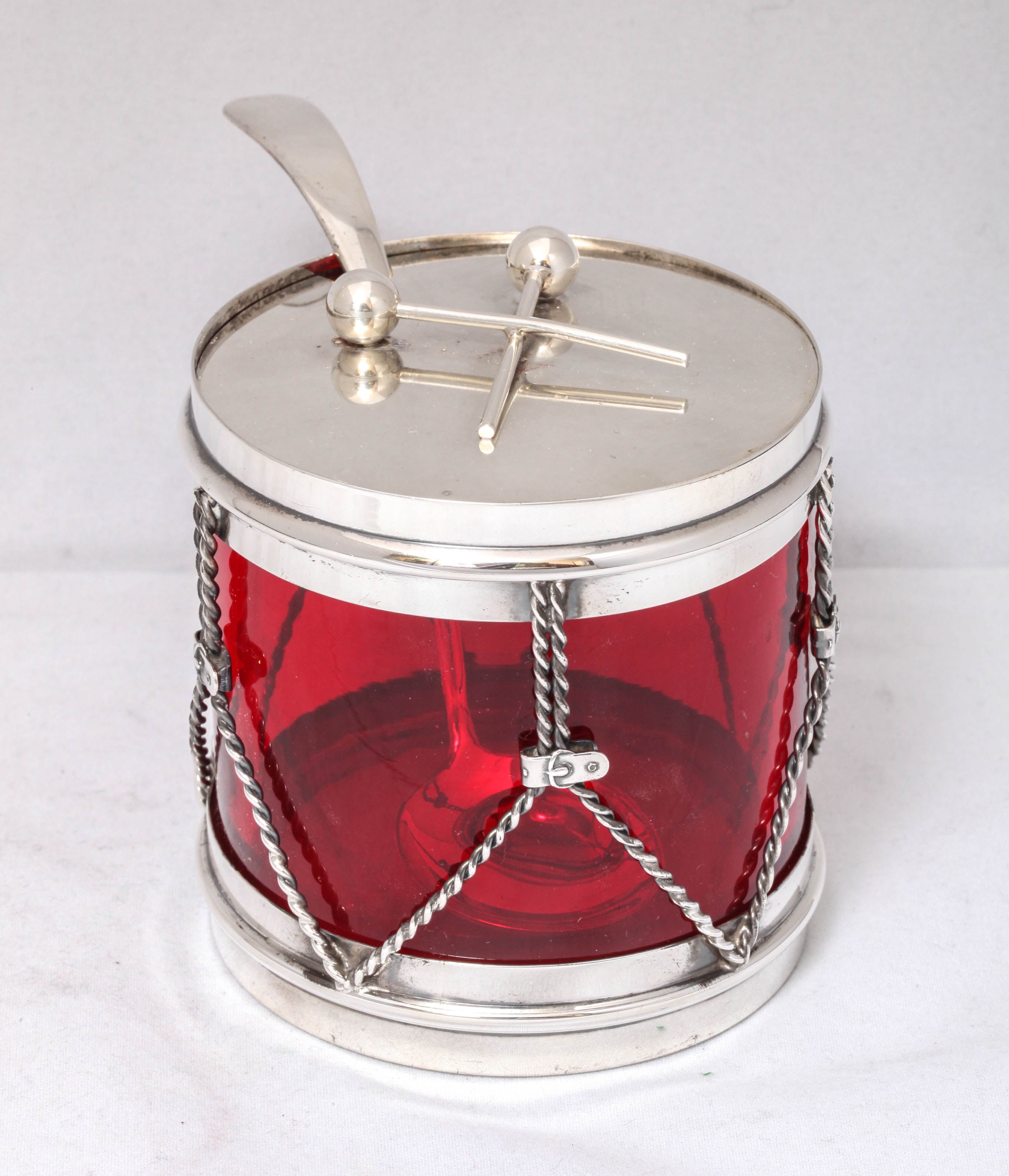 Art Deco, sterling silver-mounted ruby glass, drum-form, condiments jar with matching sterling silver spoon, R. Blackinton & Co., No. Attleboro, Mass., circa 1930s. Lid has two drumsticks which are used as the handle. Measures: 3 1/4 inches high x 3