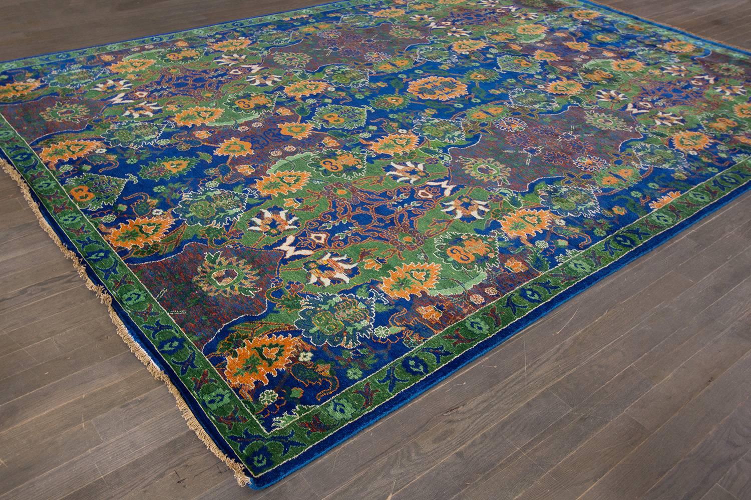 Hand-knotted Indian rug with an all-over floral design on a blue field with multicolor accents.
