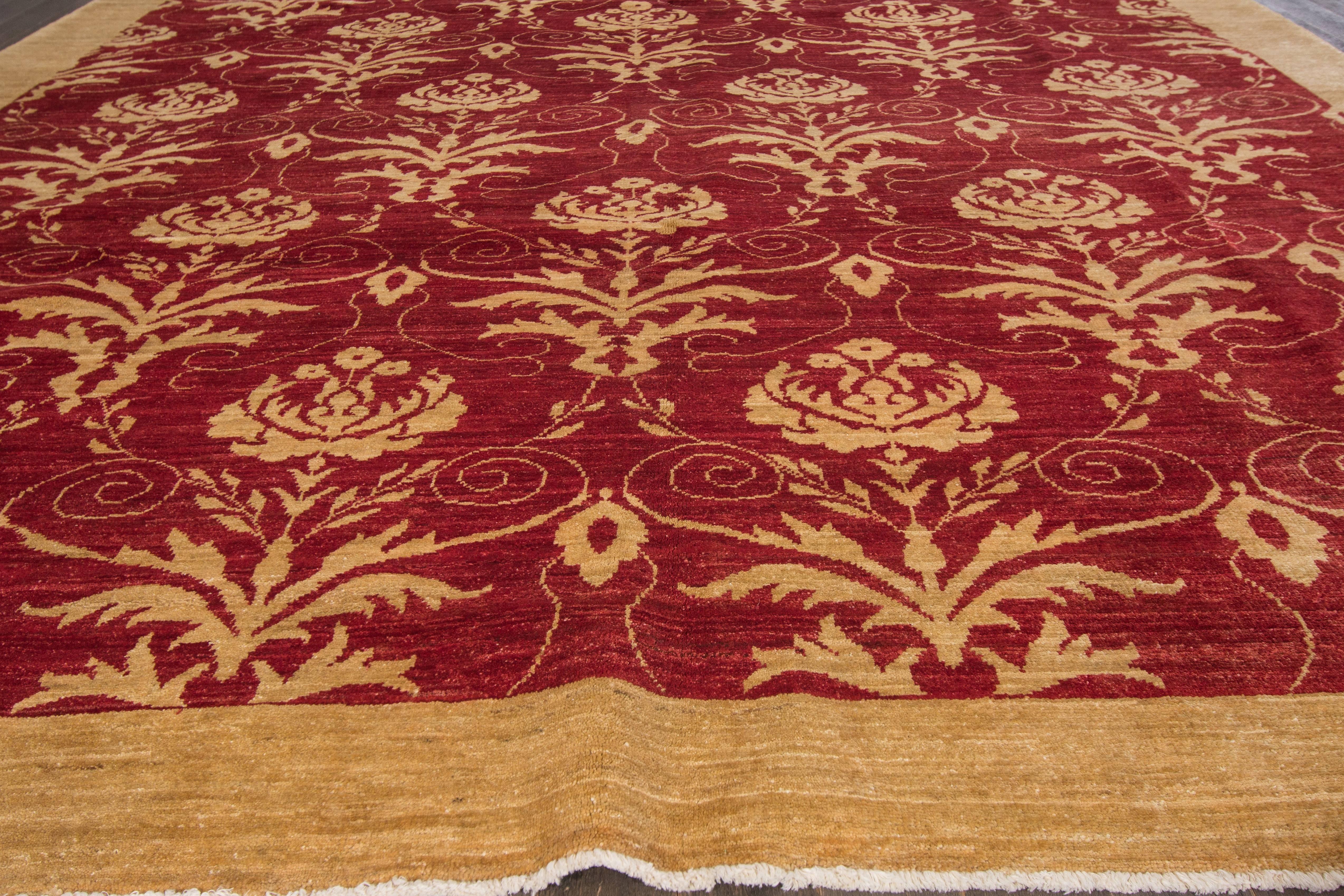 Hand knotted rug with a floral design on a red field with beige borders. 

This rug has magnificent detailing and would be perfect for any room. Measures: 11'6