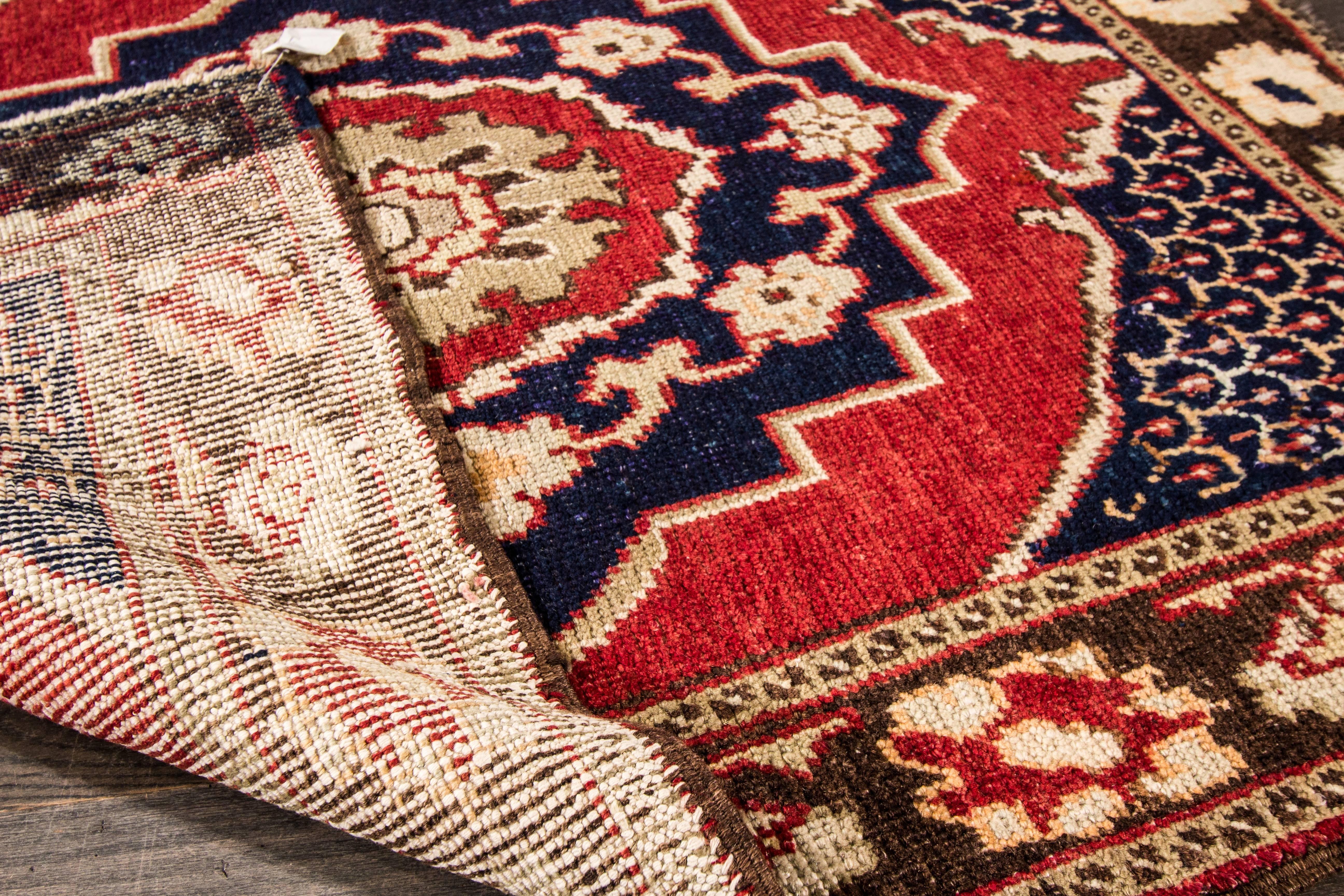 Vintage Hand-knotted rug with a geometric design on a red field with blue borders. Measures: 3'9