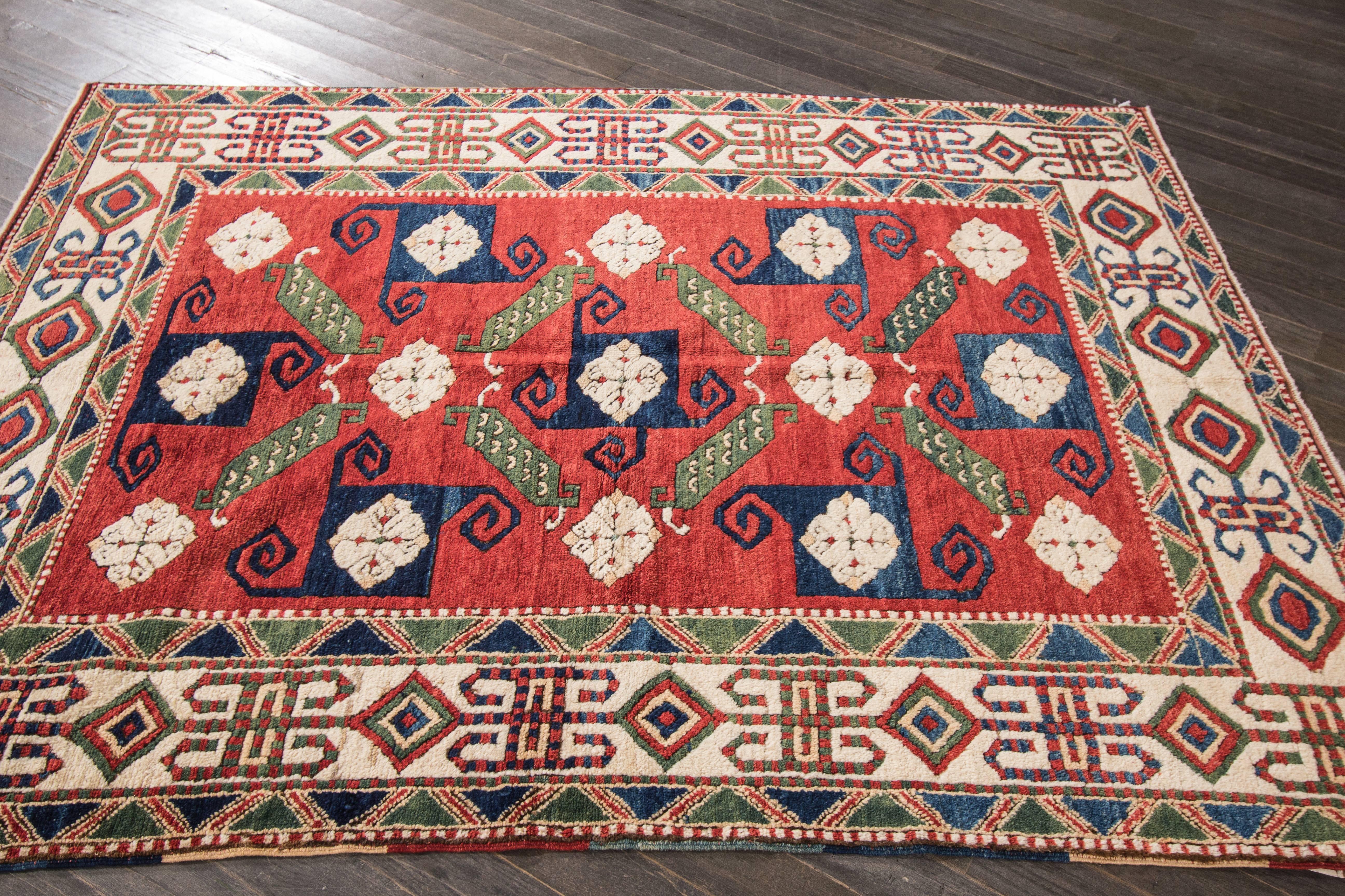 Vintage hand-knotted rug with a geometric and floral design on a red field with beige borders. Measures: 5'1