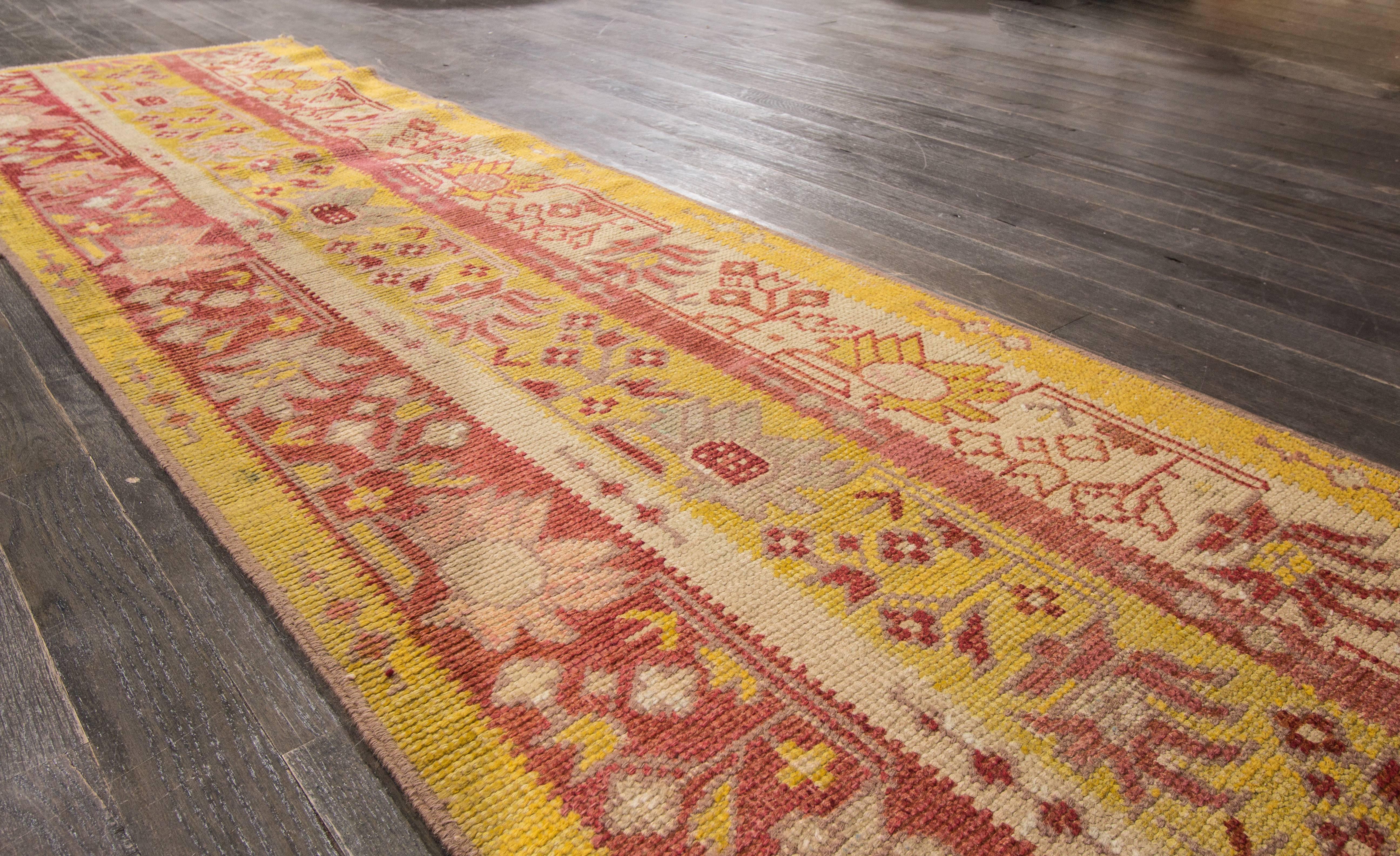 Hand-knotted rug with a floral design on a red field with yellow borders. 

This rug has magnificent detailing and would be perfect for any room. Measures: 2.6