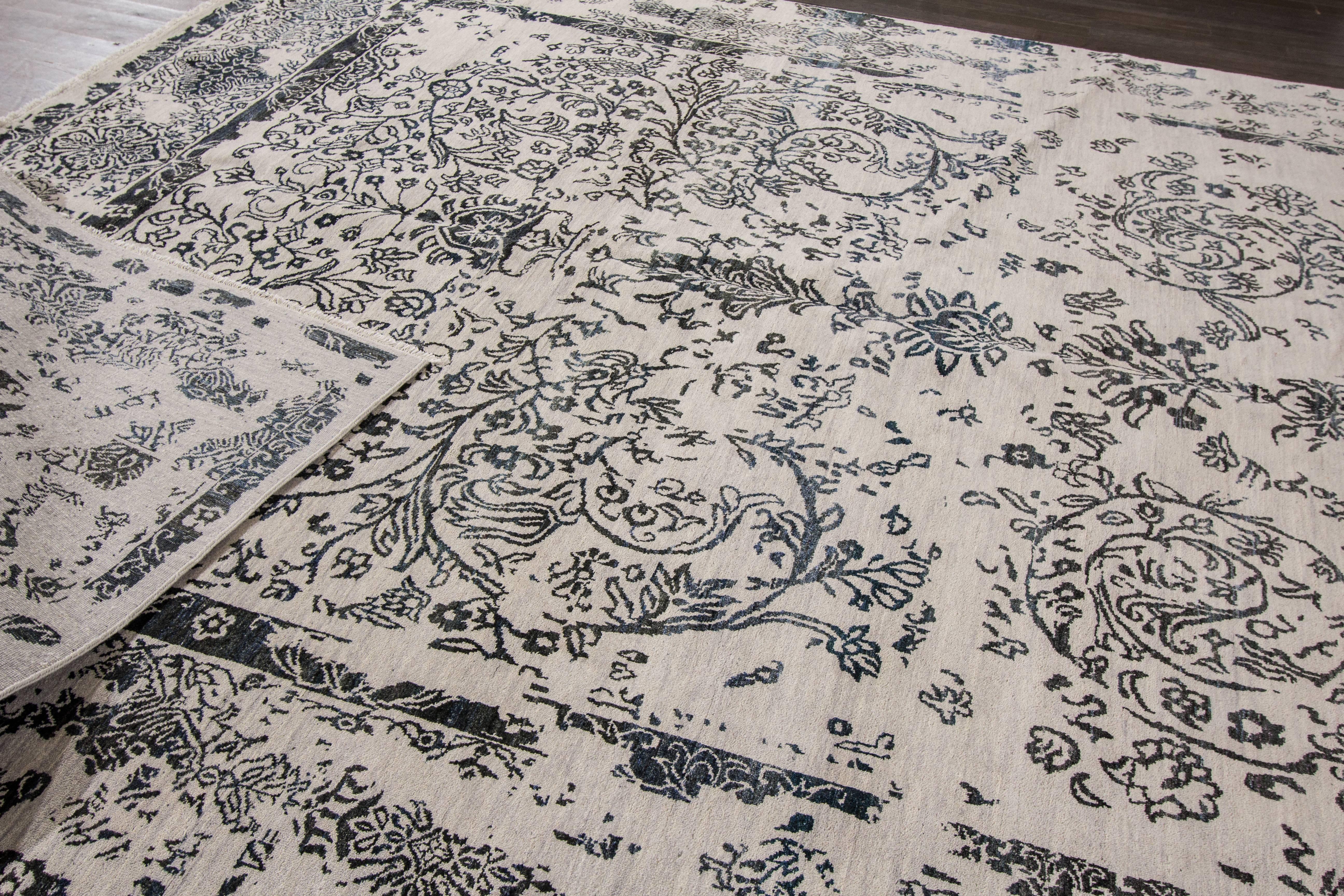 Hand-knotted rug with a floral design on an ivory field with grey borders. 

This rug has magnificent detailing and would be perfect for any room. Measures: 10' x 14'.