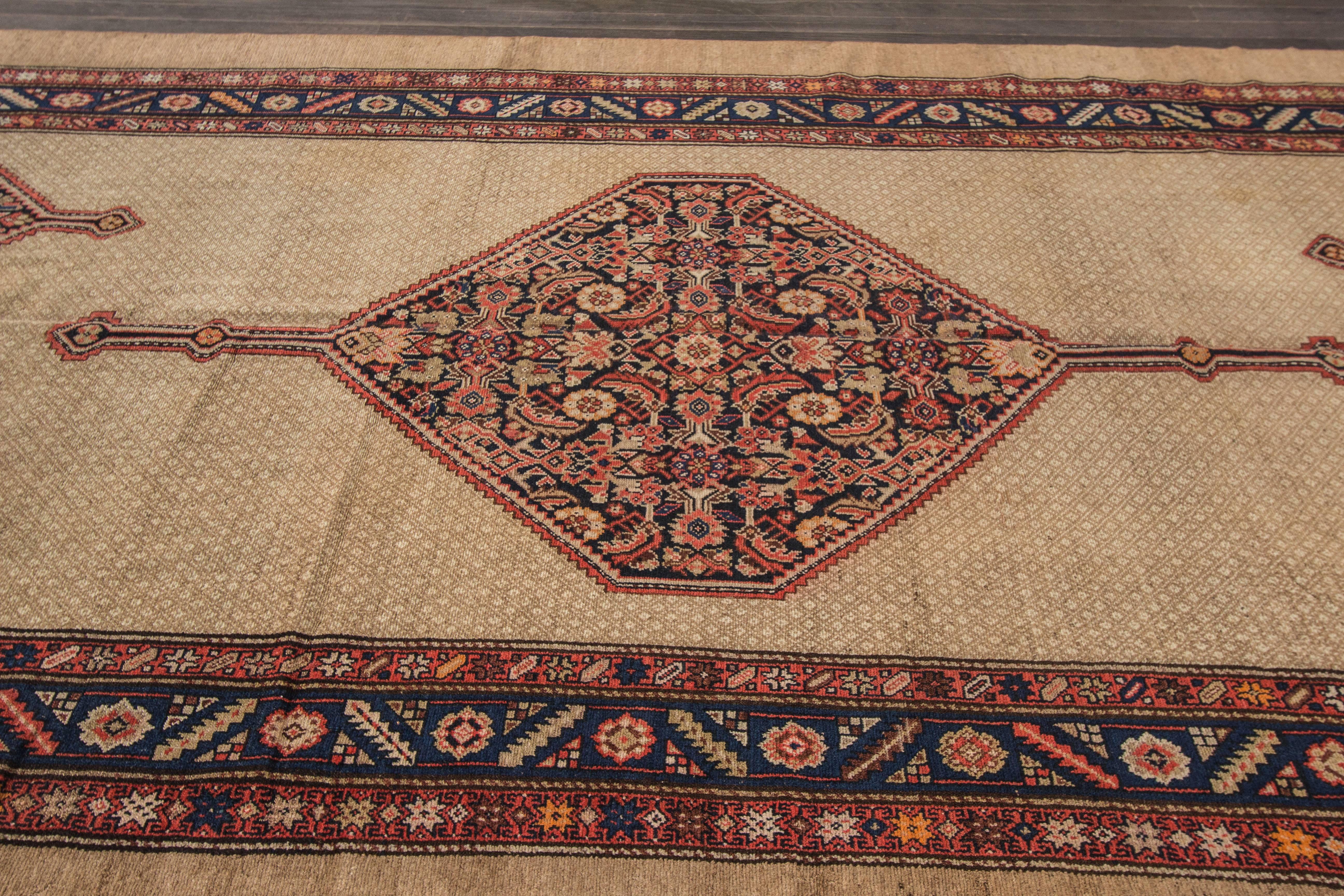 This charming village rug was woven in the vicinity of Hamadan in western Persia at the turn of the century. This format with a field of design peering out from a camel ground is reminiscent of neighbouring Serab pieces from the region. The
