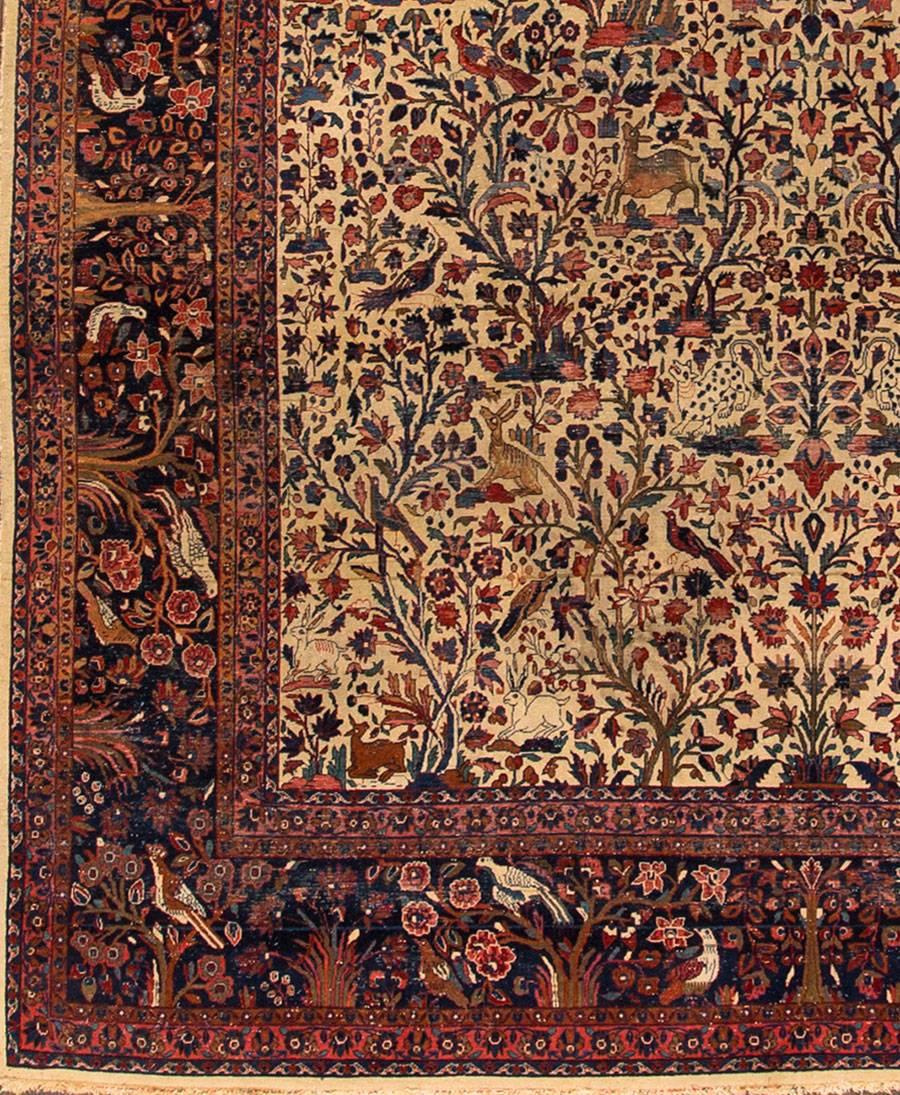 Early 20th century Persian Kashan carpet with a cream field, rust and blue accents and animal motif throughout, 7.08x10.01