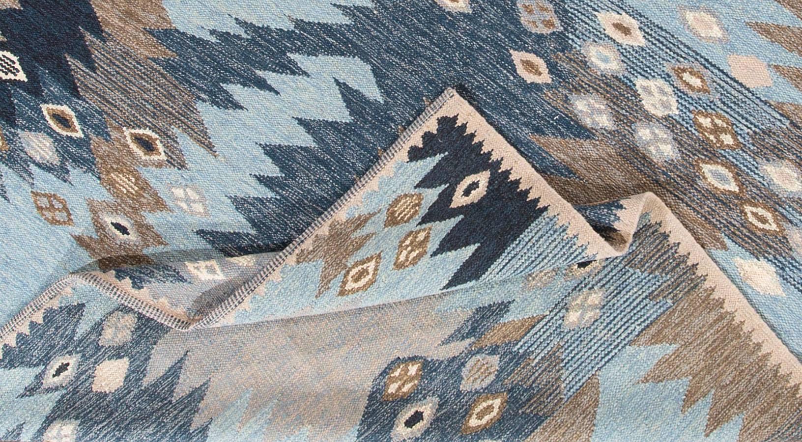 Contemporary Swedish  style rug with an abstract geometric design in blues, with gray and white accents. Measures 8.08x11.10.