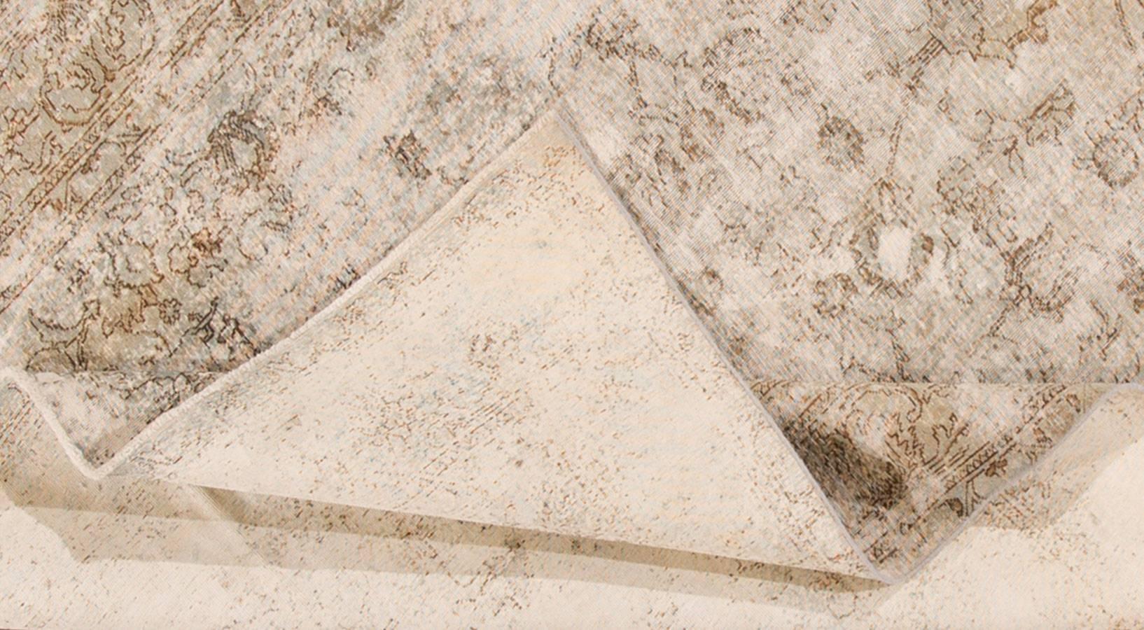 Vieux tapis persan Kerman. Cette pièce présente un champ ivoire et un motif sur toute la surface en gris plus foncé, avec un aspect vieilli. Mesures : 7.01 x 10.05.