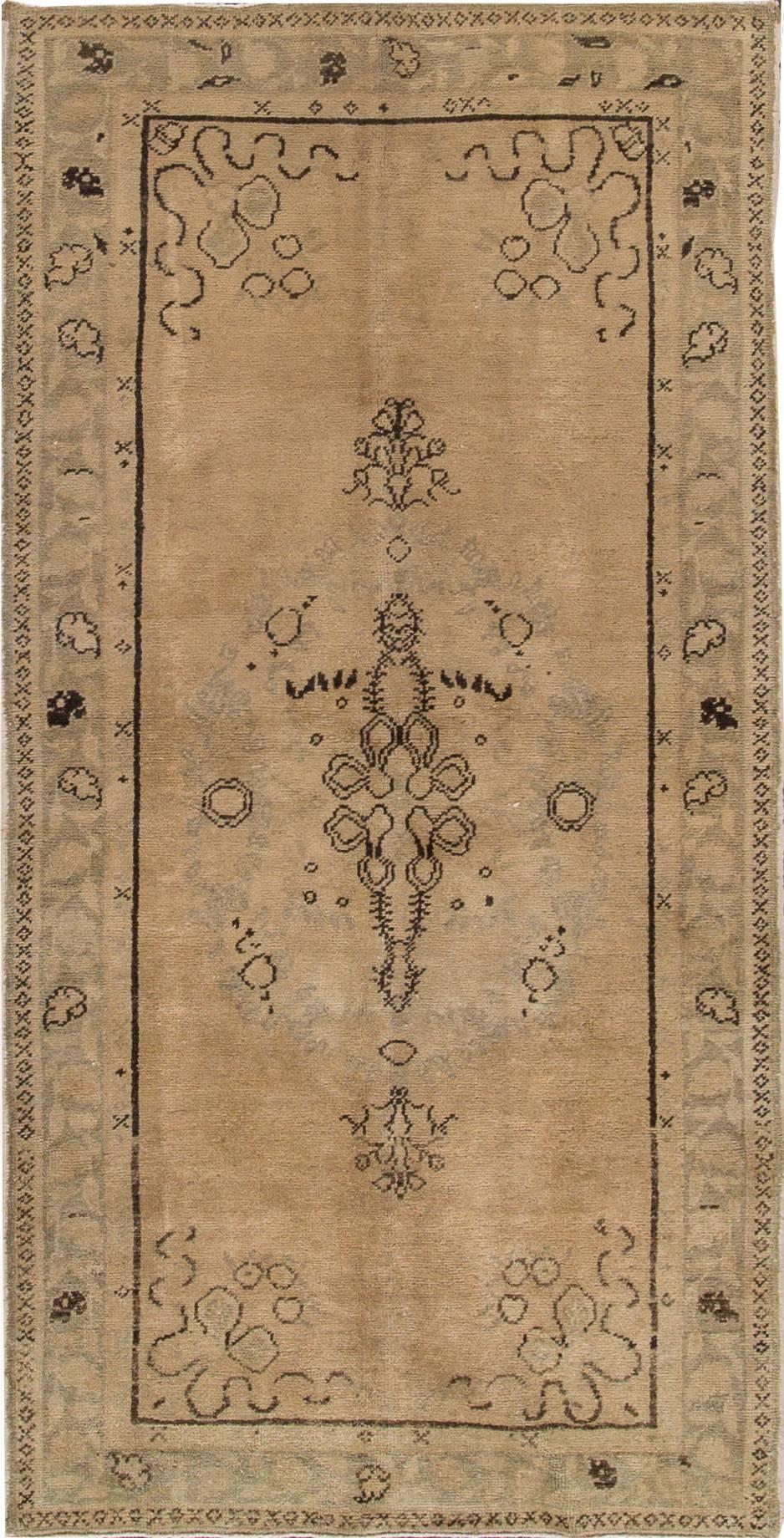20th century Turkish Khotan carpet with a beige/tan field and medallion design. Measures approximately 3 feet 3 inches by 6 feet 5 inches.