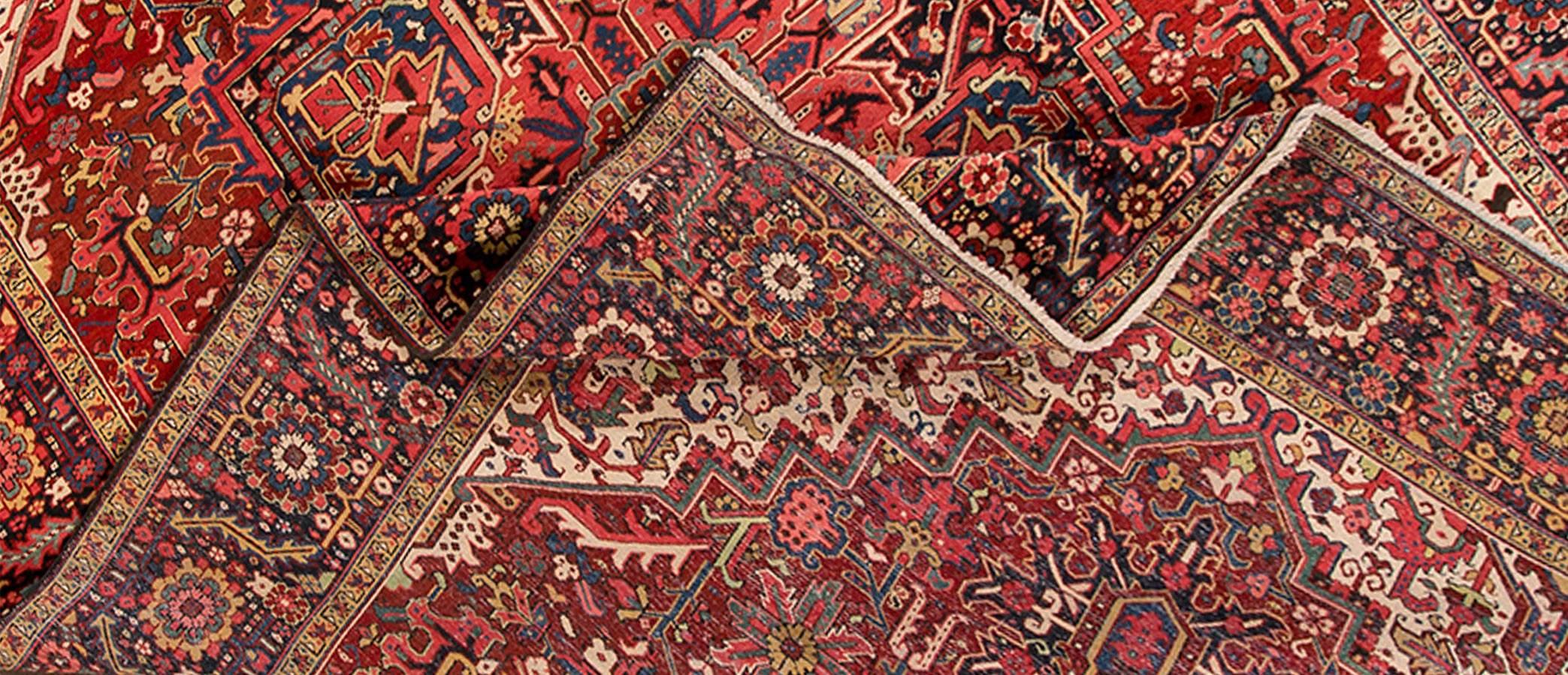 Early 20th century (1900) Persian Heriz carpet with a rust field with blue and cream accents in a traditional medallion design. Measures 10.04 x 13.09.
