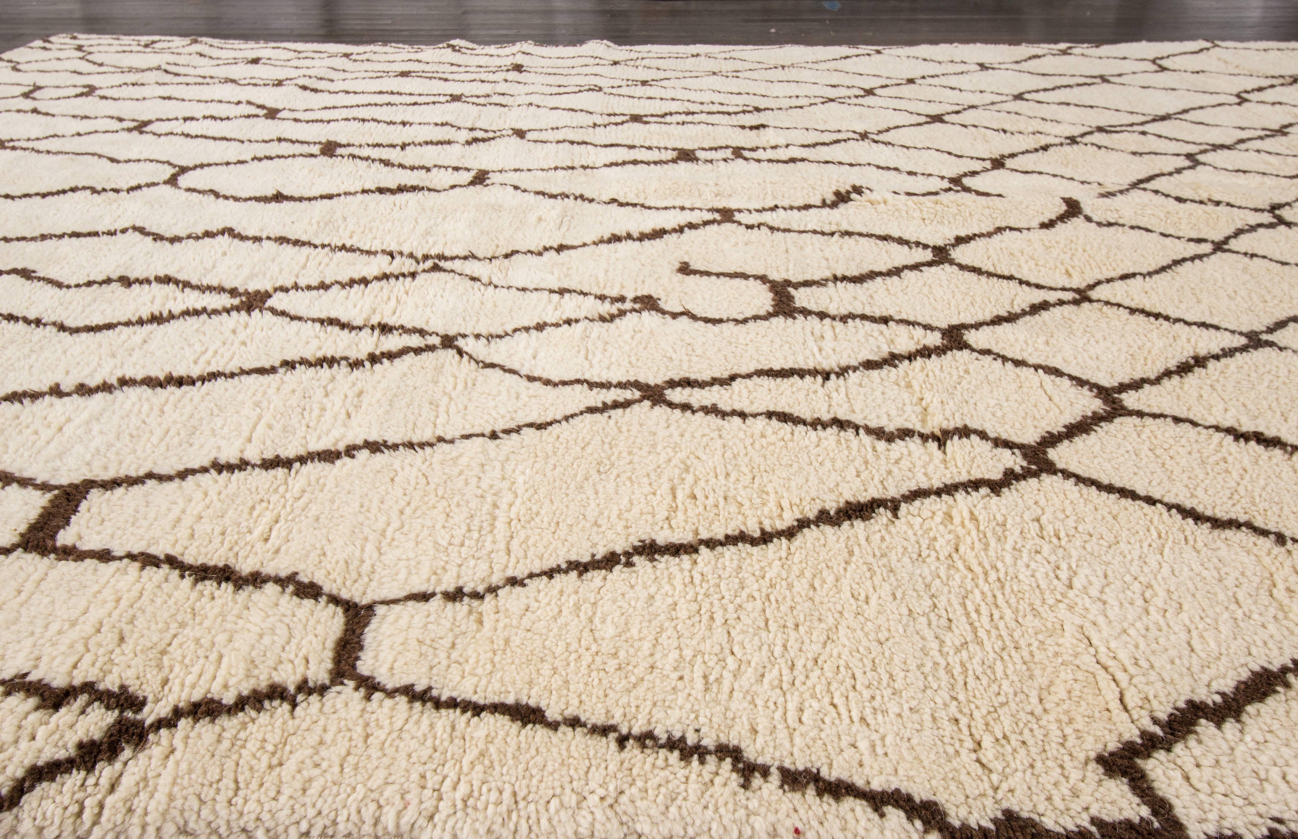 Contemporary 21st century cMoroccan rug with an ivory field and dark brown design. No border, extra-thick pile, measures approximately 8 feet 2 inches by 10 feet.