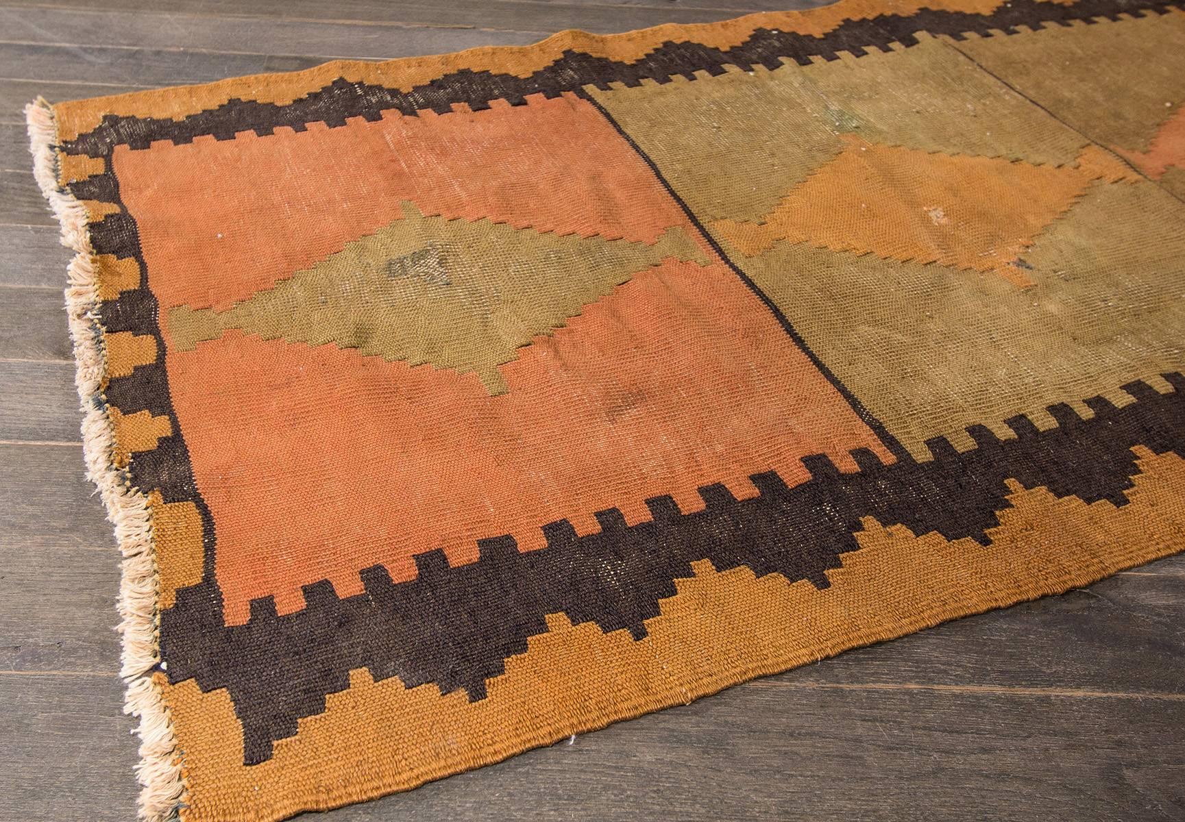 Measures: 2'.7 x 9'.10
A unique handwoven Persian Kilim rug with a geometric design and border. Accents of green, orange and brown throughout the piece.
Persian Kilim rug, which are more like tapestries, soft and thin and used as sofa covers or