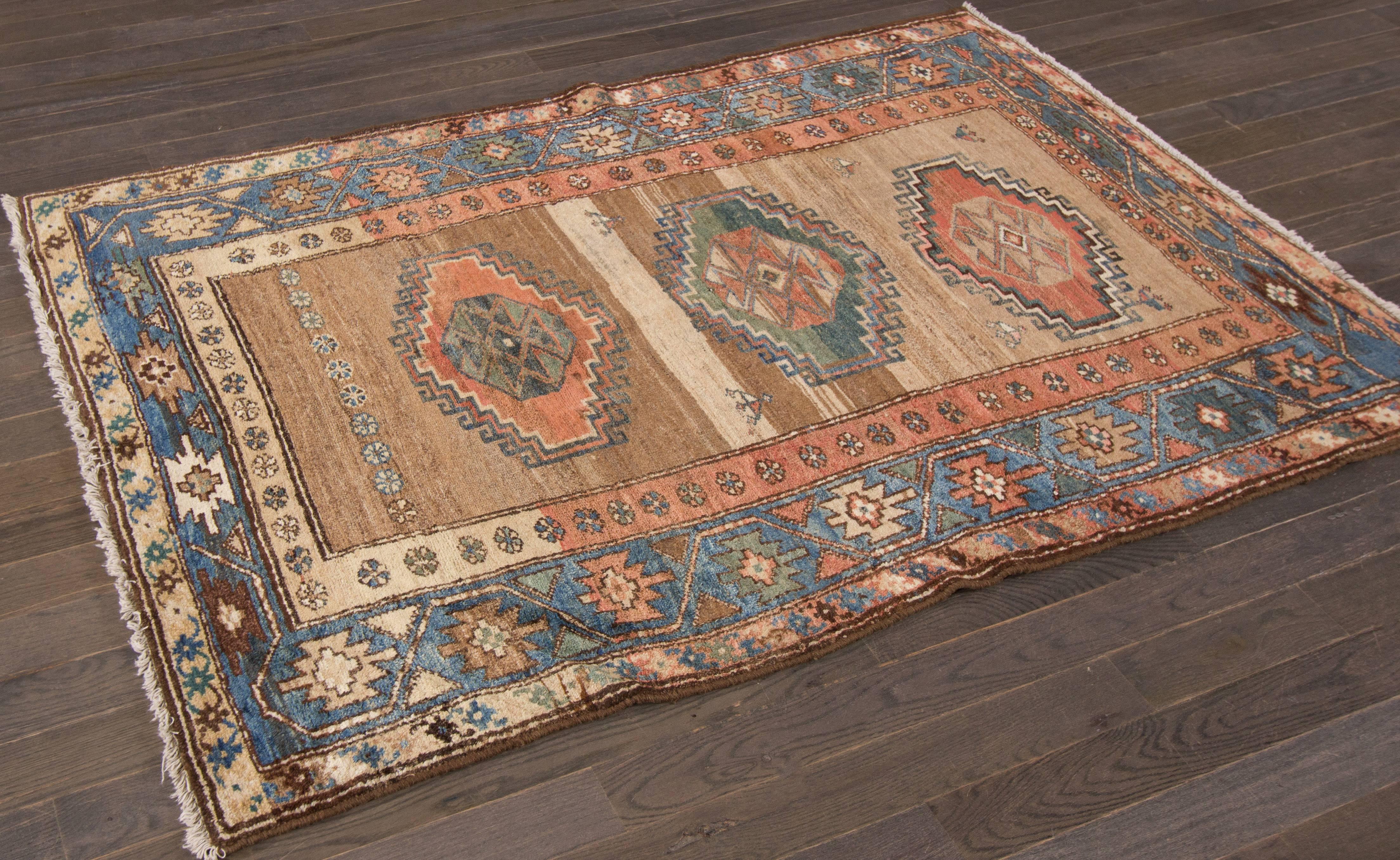 5'.A hand-knotted Camelhair Kurd rug with a geometric design on a beige field. Accents of blue, red and ivory throughout the piece. This rug measures 3'.10 x 5'.8.