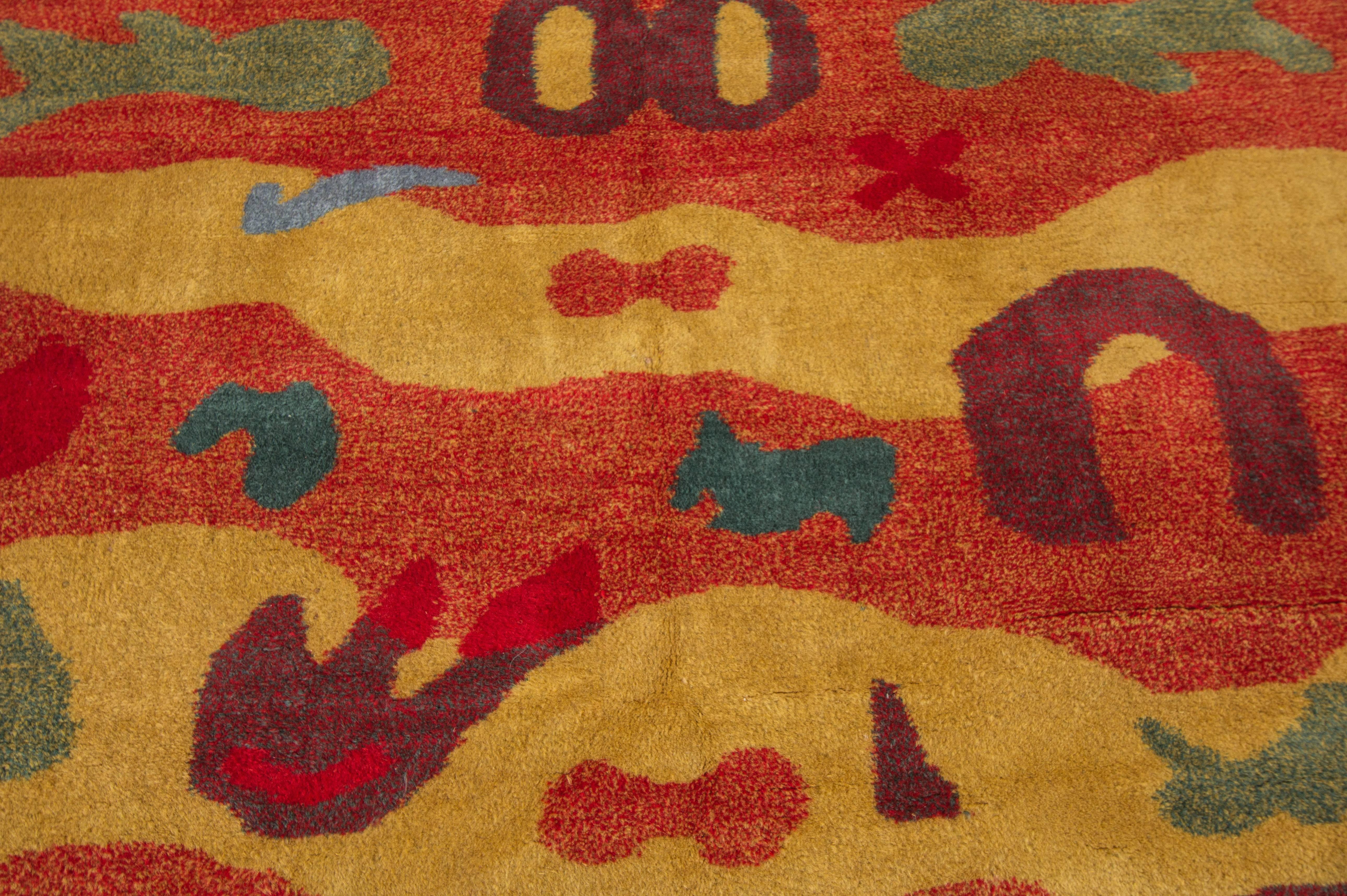 A vintage Turkish rug with an artistic design on a yellow and orange field. Accents of blue, green and purple throughout the piece in artistic designs. Measures 5' x 8'.3.