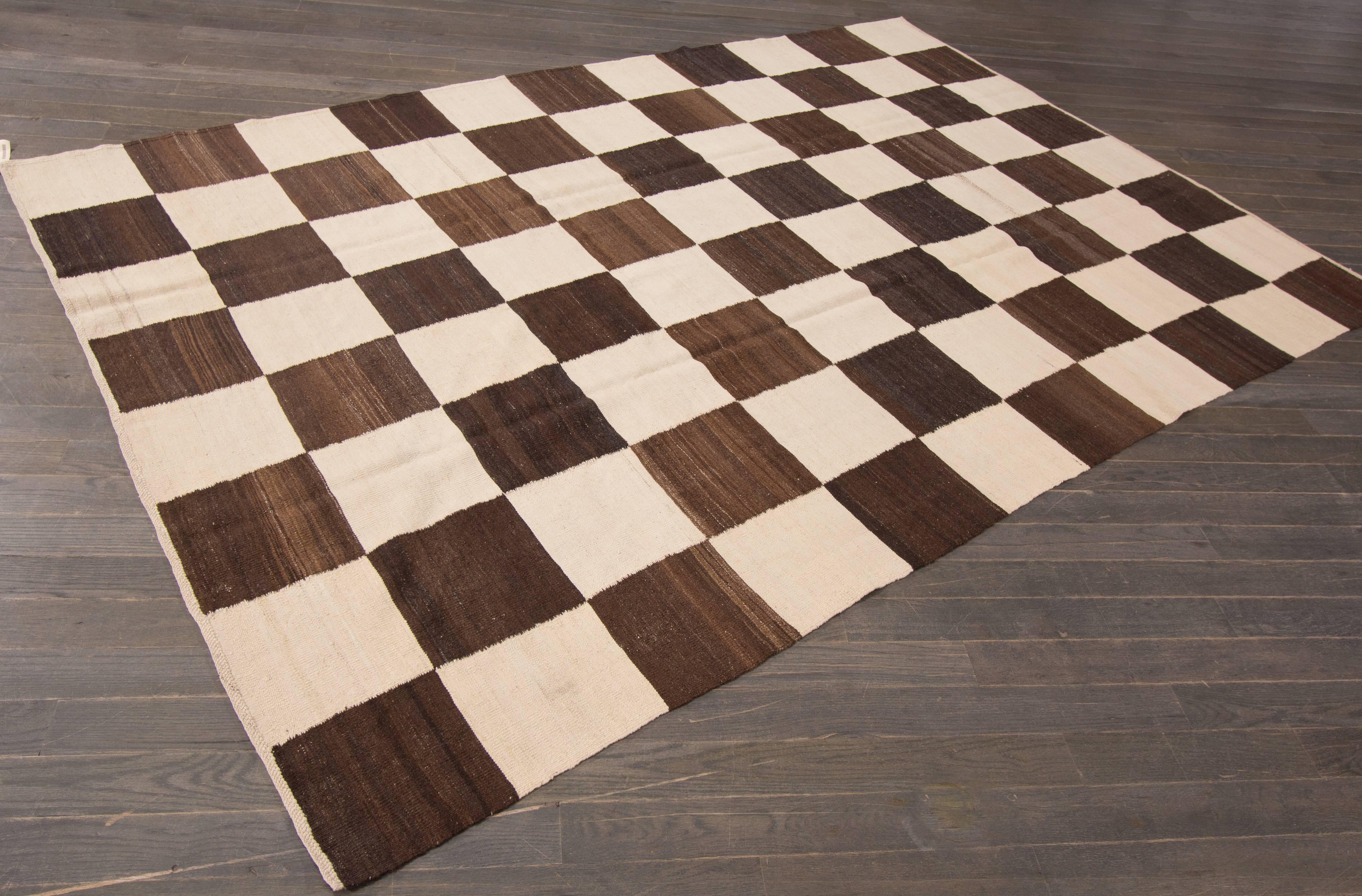 A hand-knotted Kilim rug with a checkered brown and ivory pattern. This rug measures 6' x 8'.10.