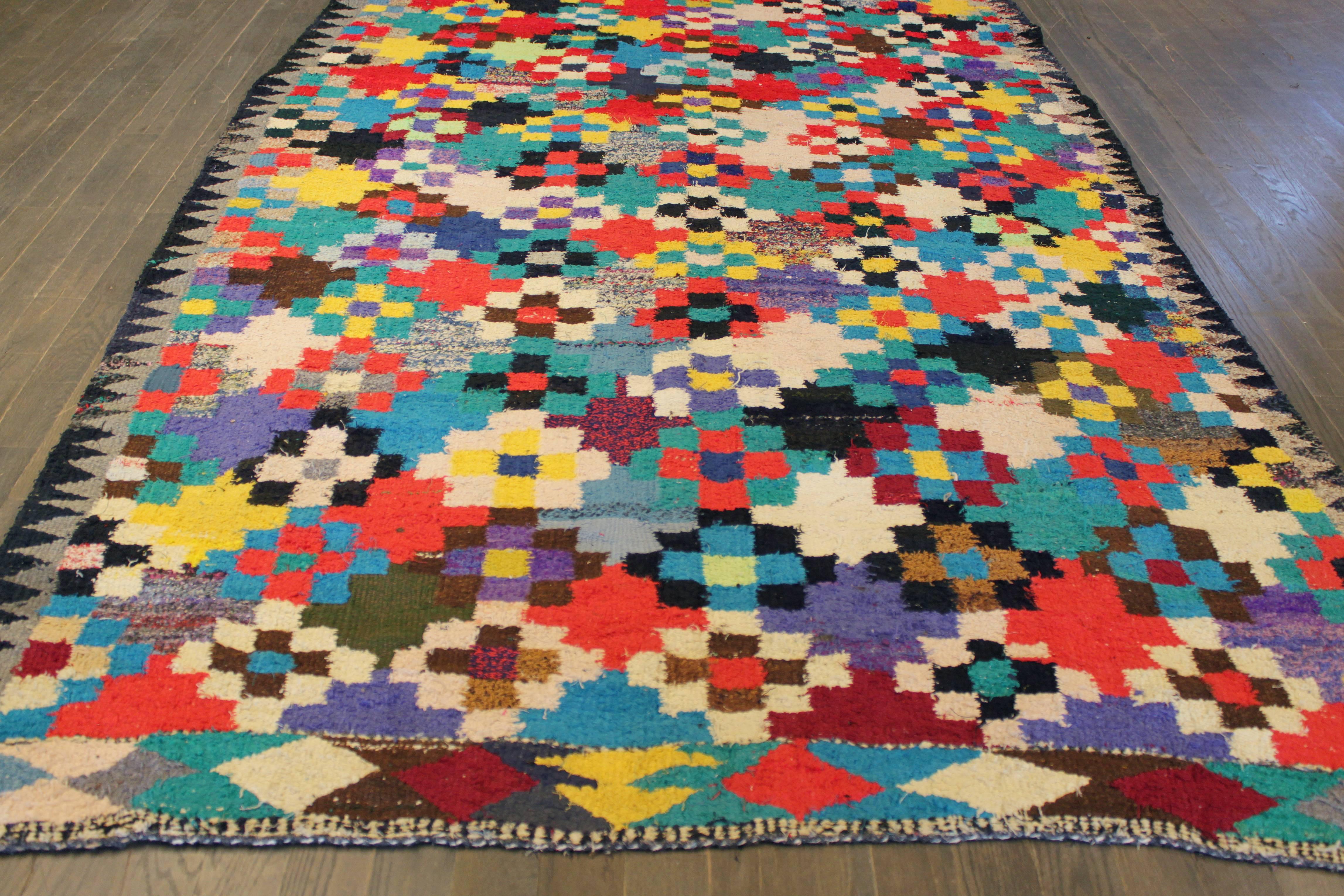 Ein handgeknüpfter Kelim-Teppich mit einem kunstvollen Muster auf einem schwarzen Feld. Akzente in Gelb, Blau, Braun und Elfenbein im gesamten Stück. 
Maße: 6'.3 x 11'.5.