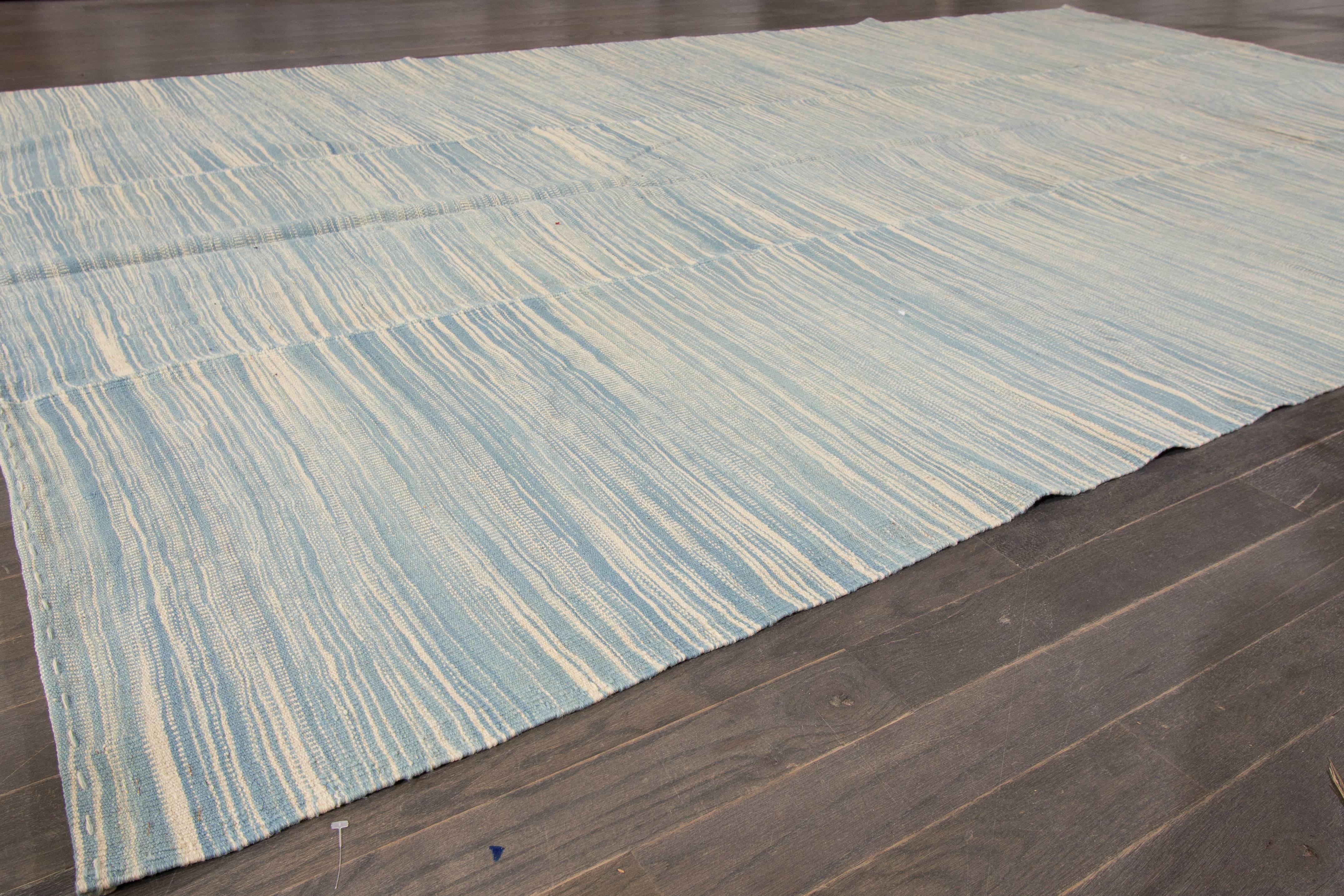 21st century contemporary Turkish Kilim rug with an all-over pale blue and ivory textured field. Measures 6.08x10.11.