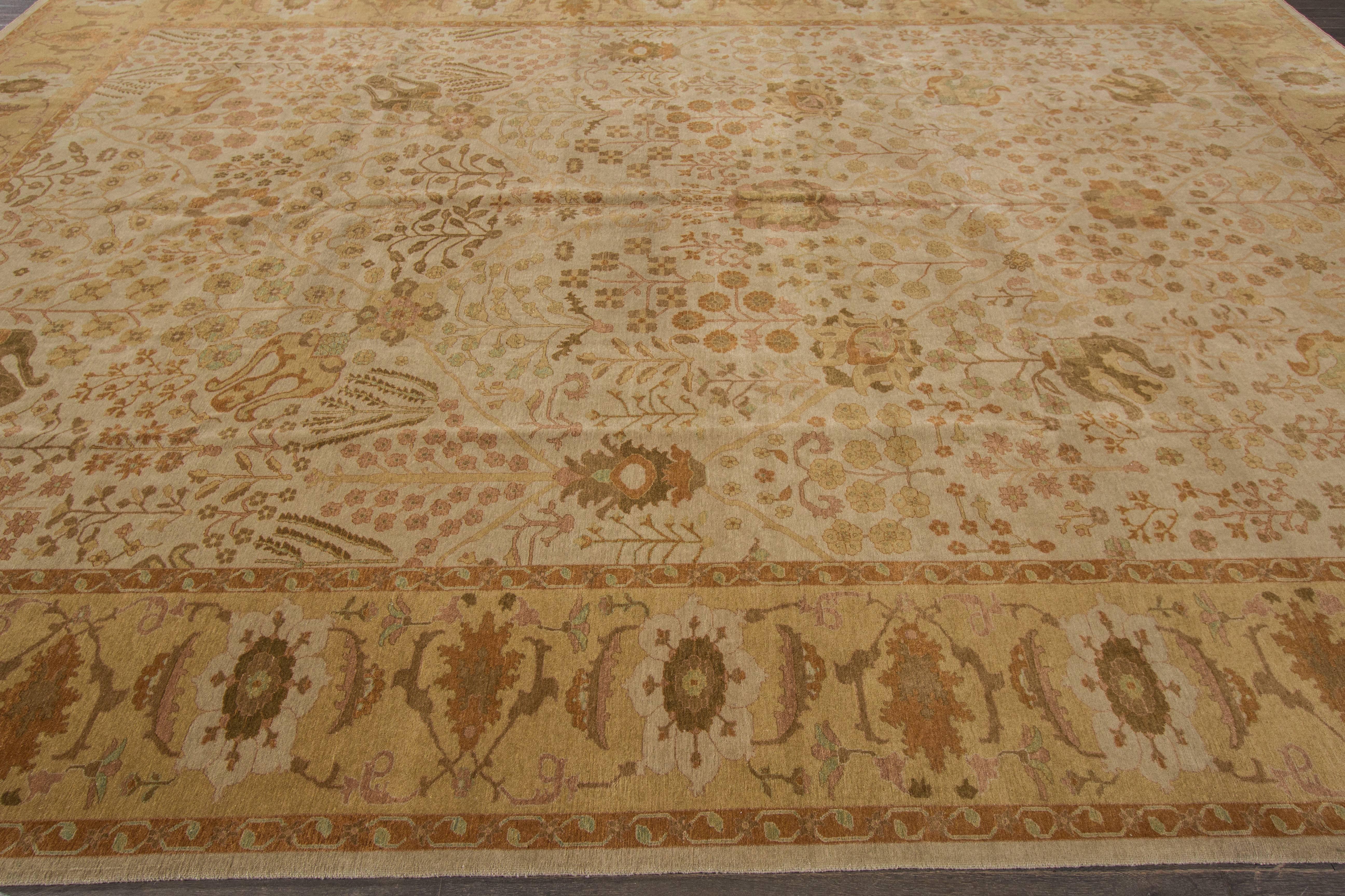 Un tappeto Tabriz annodato a mano con un disegno geometrico in campo beige. Accenti di verde e marrone in tutto il pezzo. Questo tappeto misura 10'.2 x 14'.