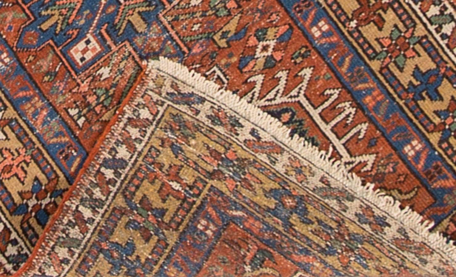 Vintage 1920s Persian Heriz runner carpet with a rust/burnt orange field and traditional all-over design in blue and green tones. Measures 2.10x10.04.