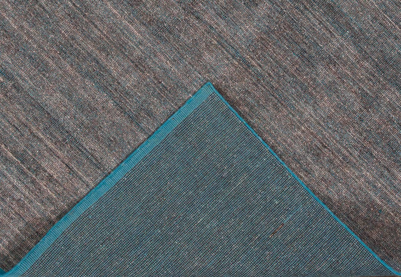 Apadana Beautiful modern handmade Indian bamboo and silk boho rug with a gray and teal field. This boho collection rug has a teal border in an all-over solid design.

This rug measure: 8' x 10' 

Custom colors and sizes available upon request.