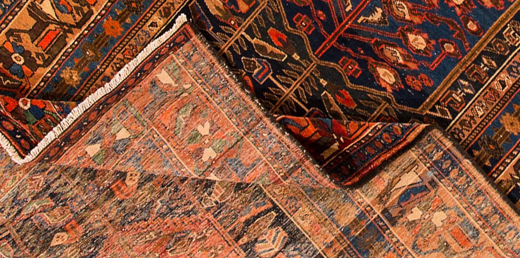 Antiker Perserteppich mit dunklem Rostfeld und traditionellem Muster in Dunkelblau mit cremefarbenen Akzenten. Maße: 5,09 x 11,04.