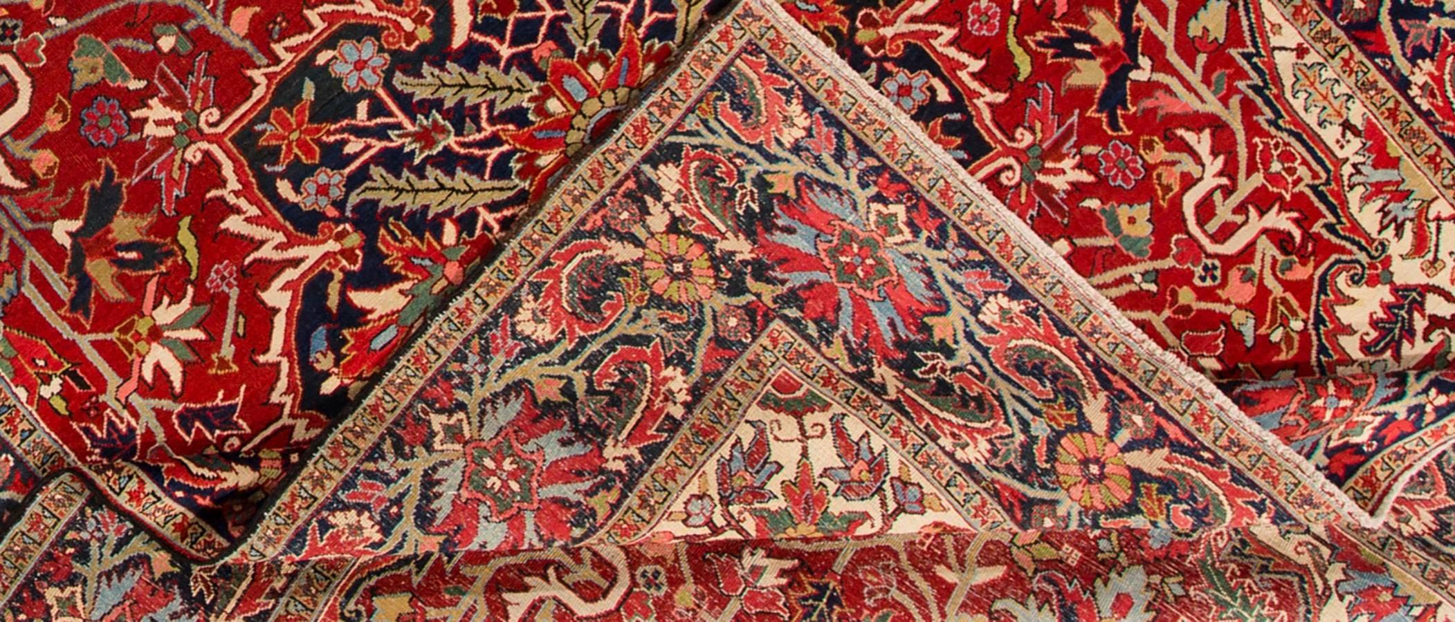 Antique Persian Heriz carpet with a rust or red field and blue-black medallion design with cream and lighter blue accents. Measures: 8.09 x 11.09.