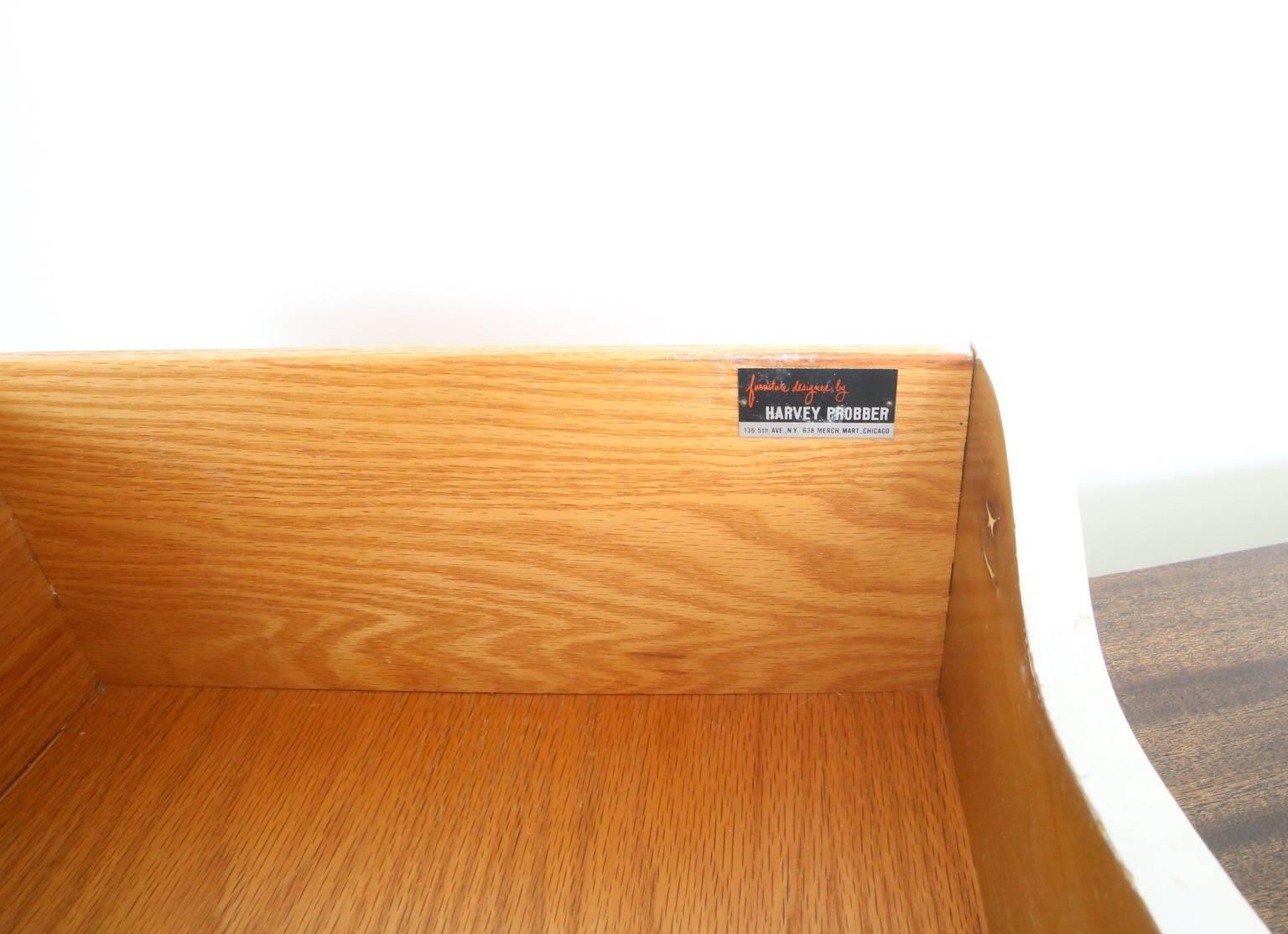 Mahogany and front canning two-door credenza by Harvey Probber. Two sliding doors open to reveal shelving on the right and four drawers on the left. Original tag inside top drawer.